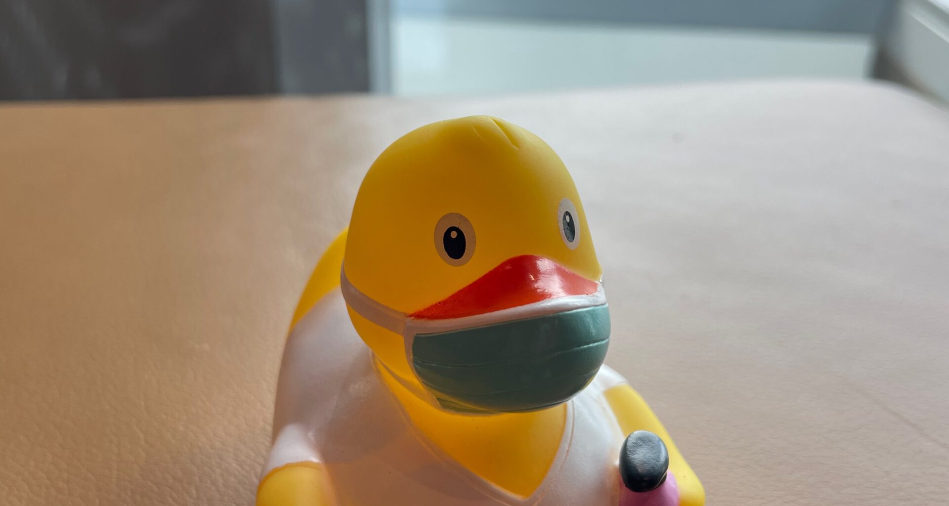 a yellow rubber duck with a face mask