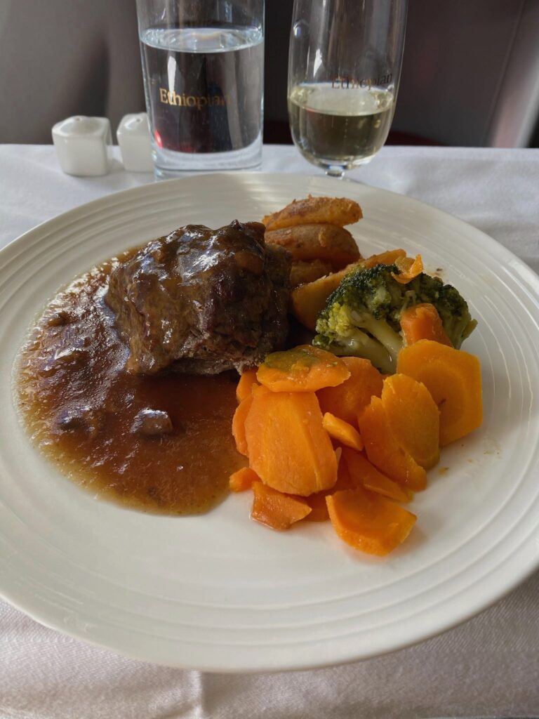 a plate of food with a glass of water and a glass of liquid