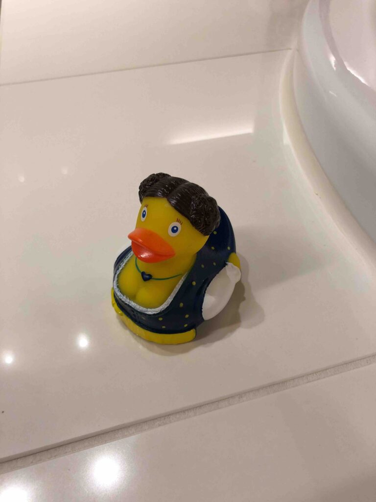 a yellow rubber duck on a white surface