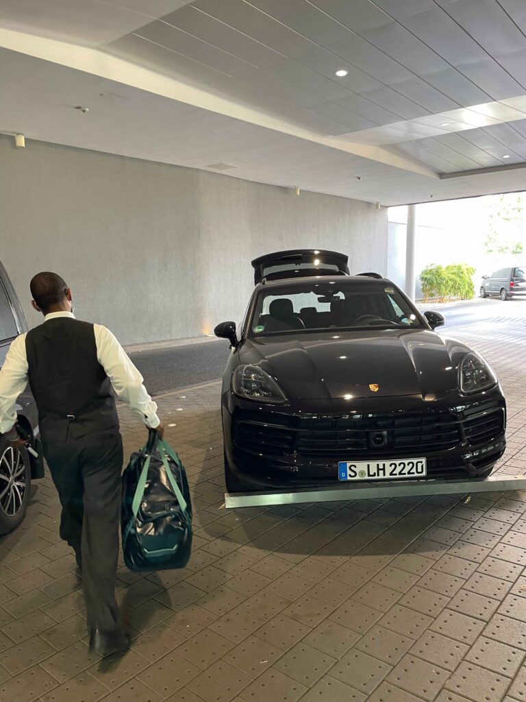 a man carrying a bag walking towards a car