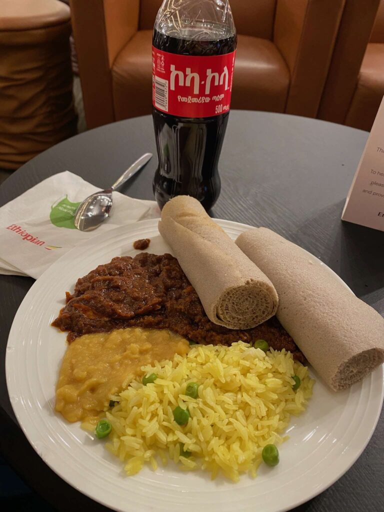 a plate of food and a soda bottle