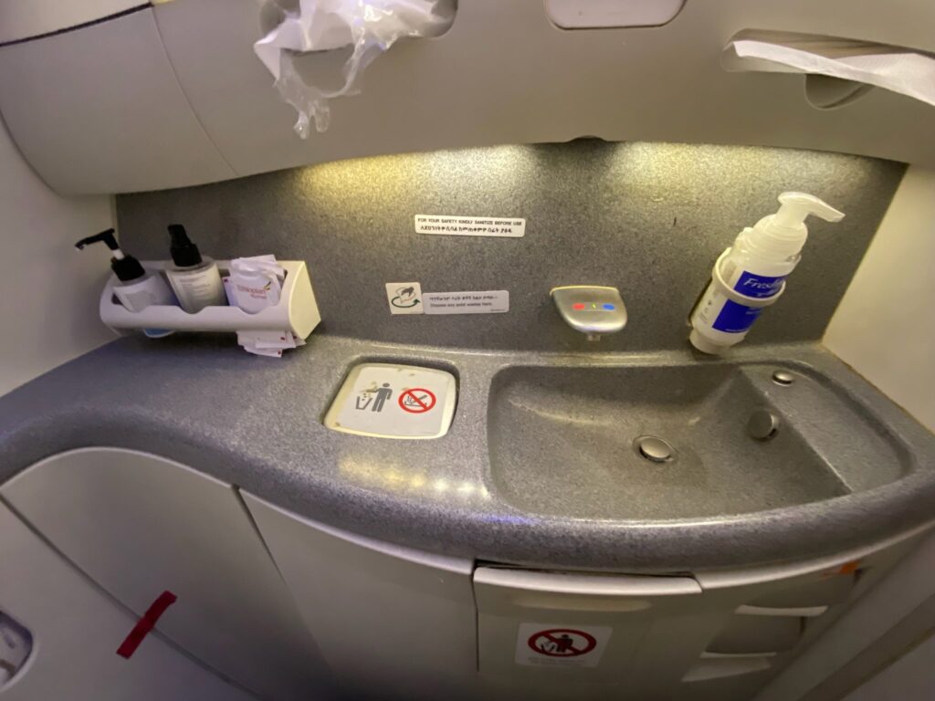 a sink and soap bottles on a plane