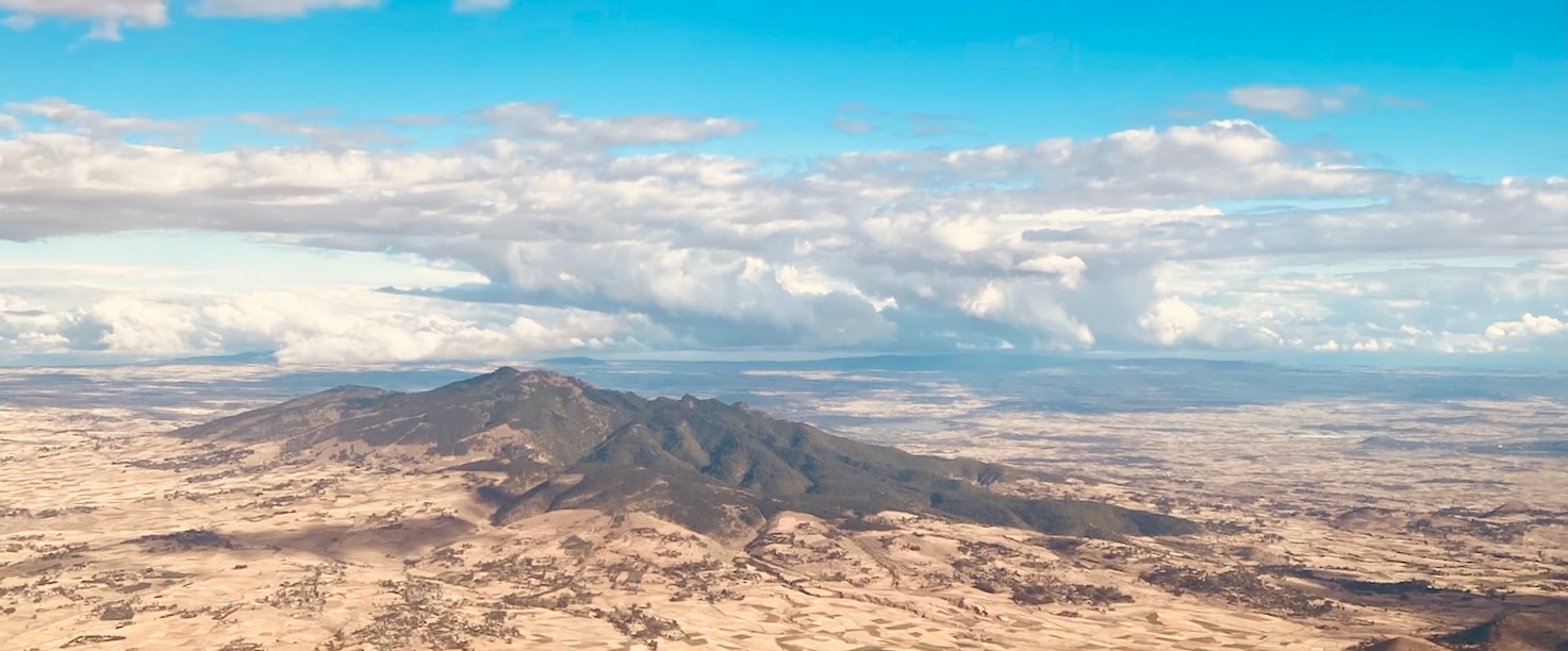 a landscape with a mountain and clouds in the sky