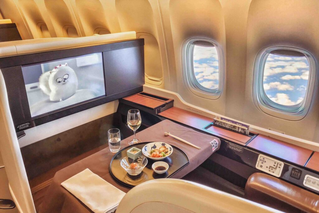 a table with food on it and a television on the side of the plane