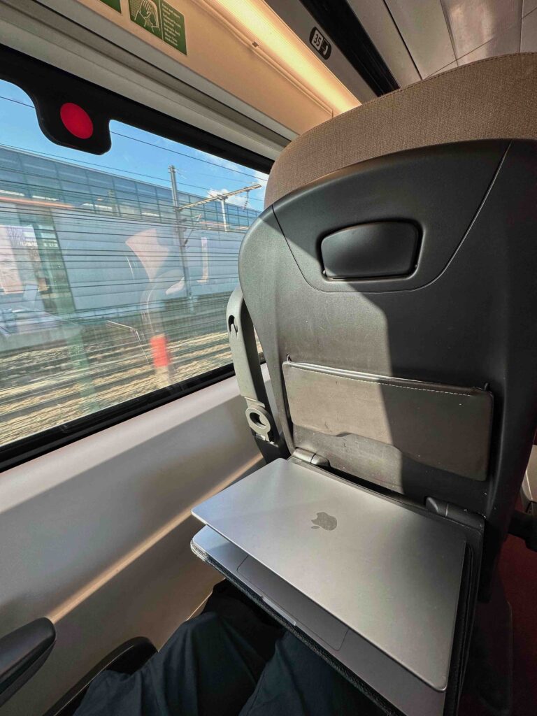a laptop on a seat in a train