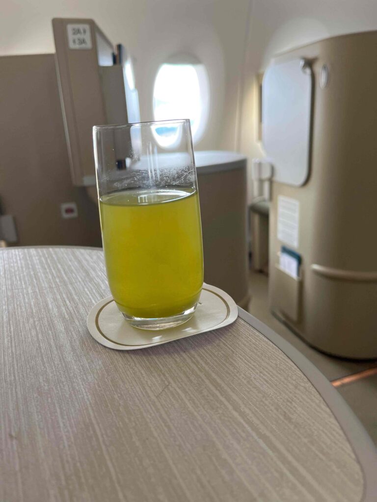 a glass of yellow liquid on a table