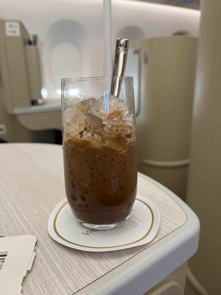 a glass with ice and brown liquid on a table