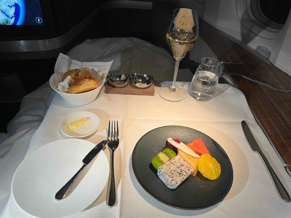 a plate of fruit and a glass of wine on a table