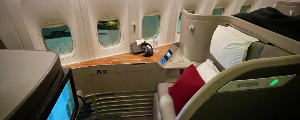 a seat with a pillow and headphones on the side of the seat