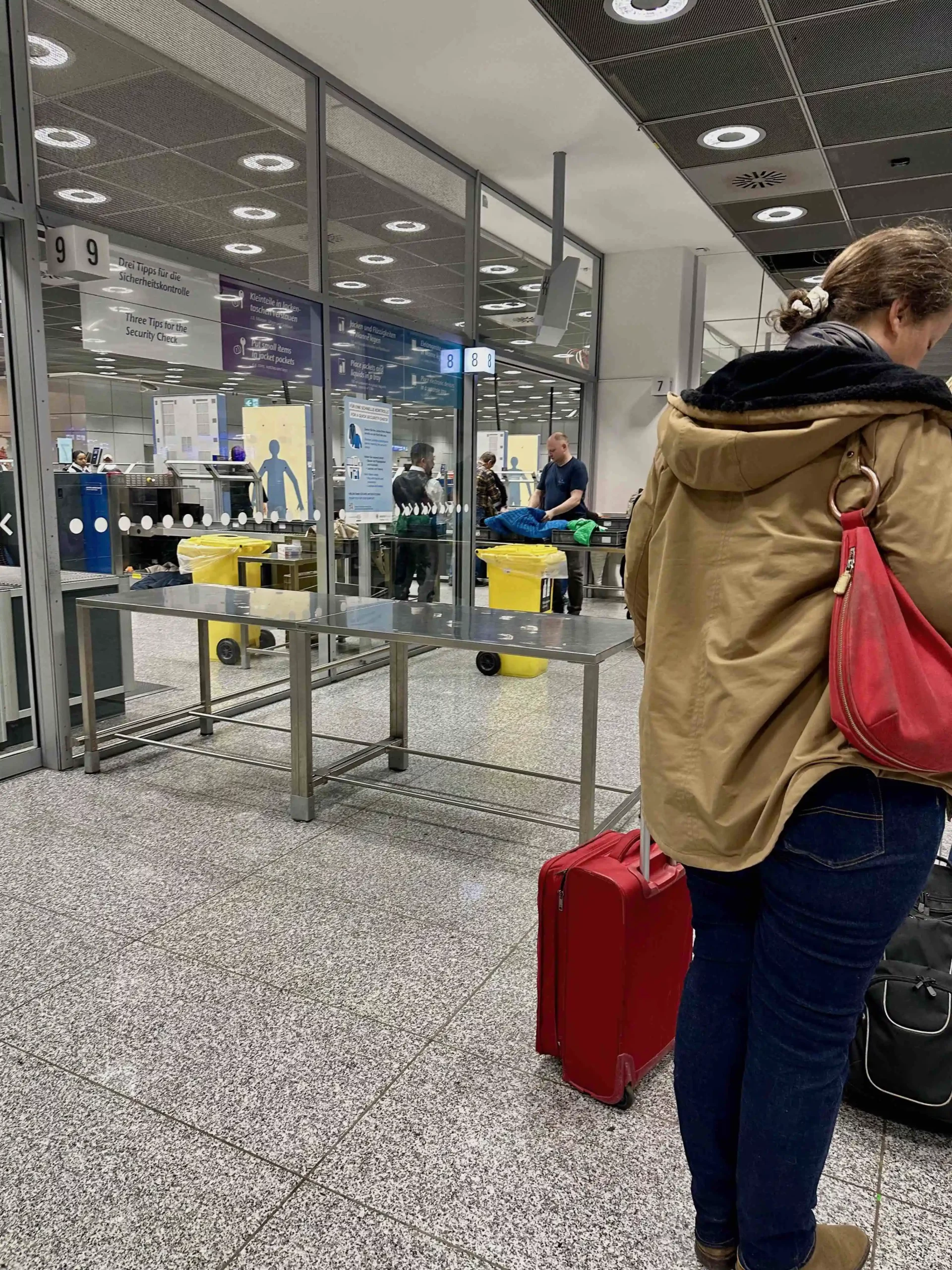 a woman standing in front of a glass wall with luggage