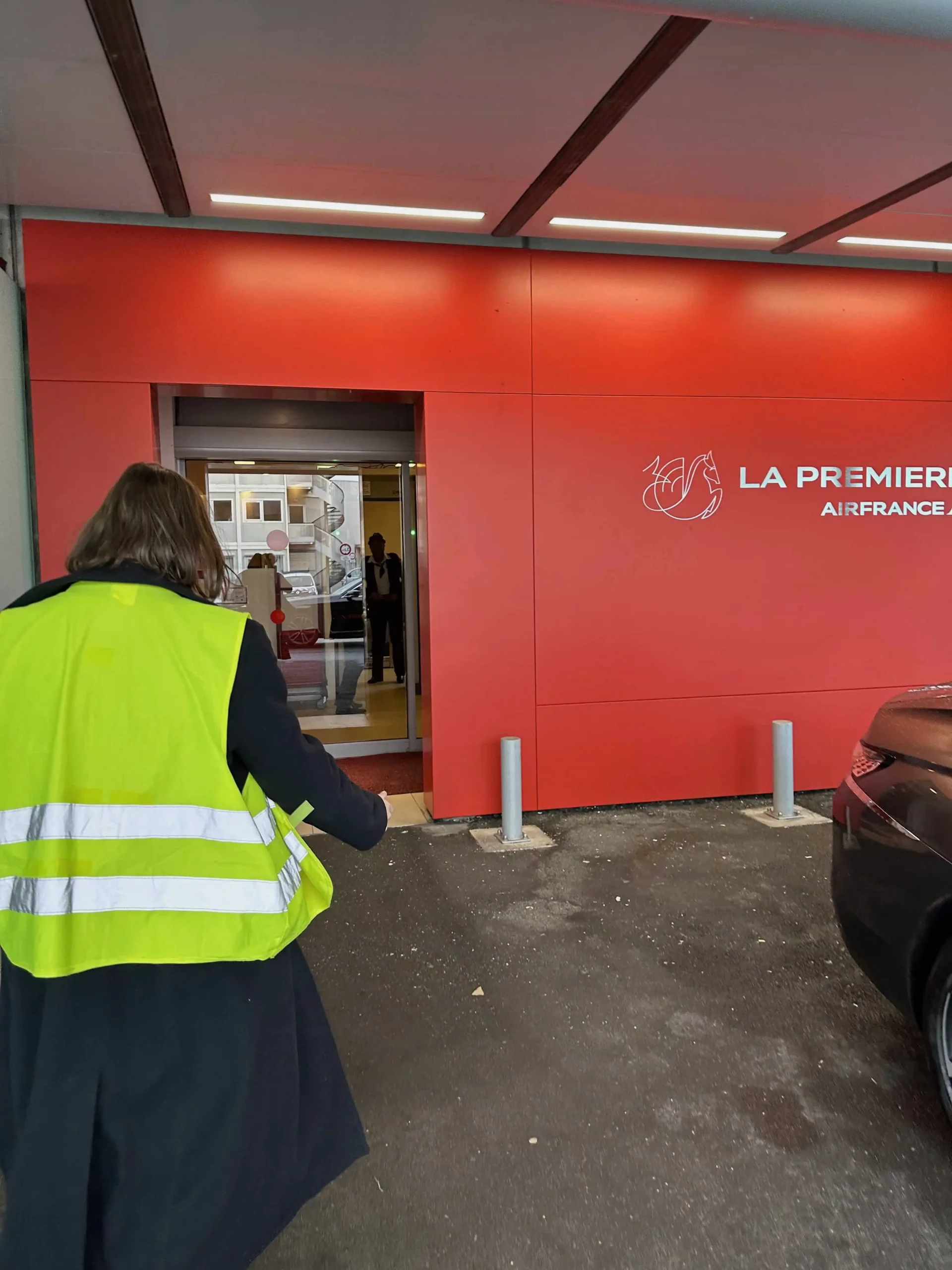 a woman in a yellow vest outside a building