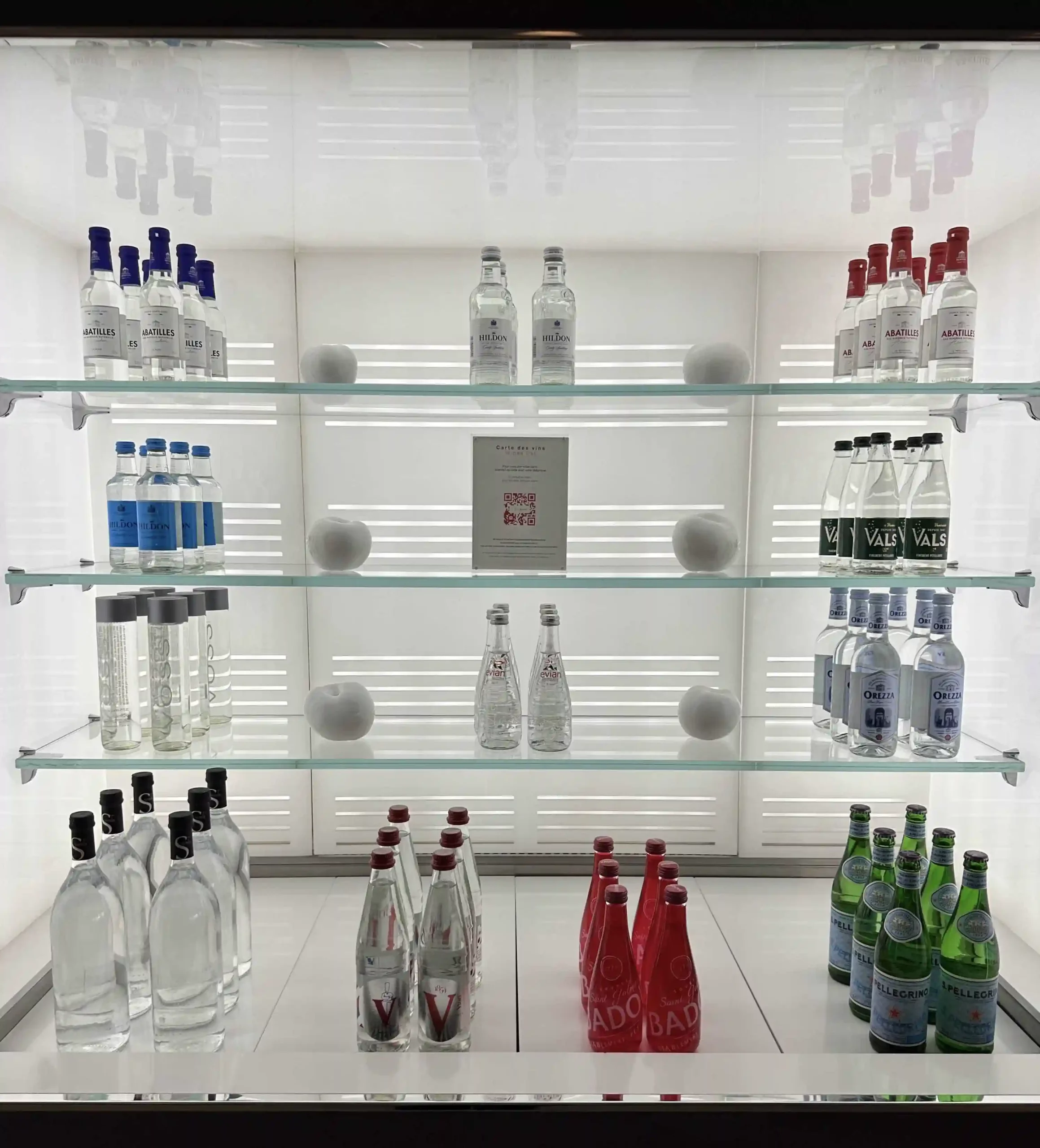 a glass shelves with bottles and bottles of liquid