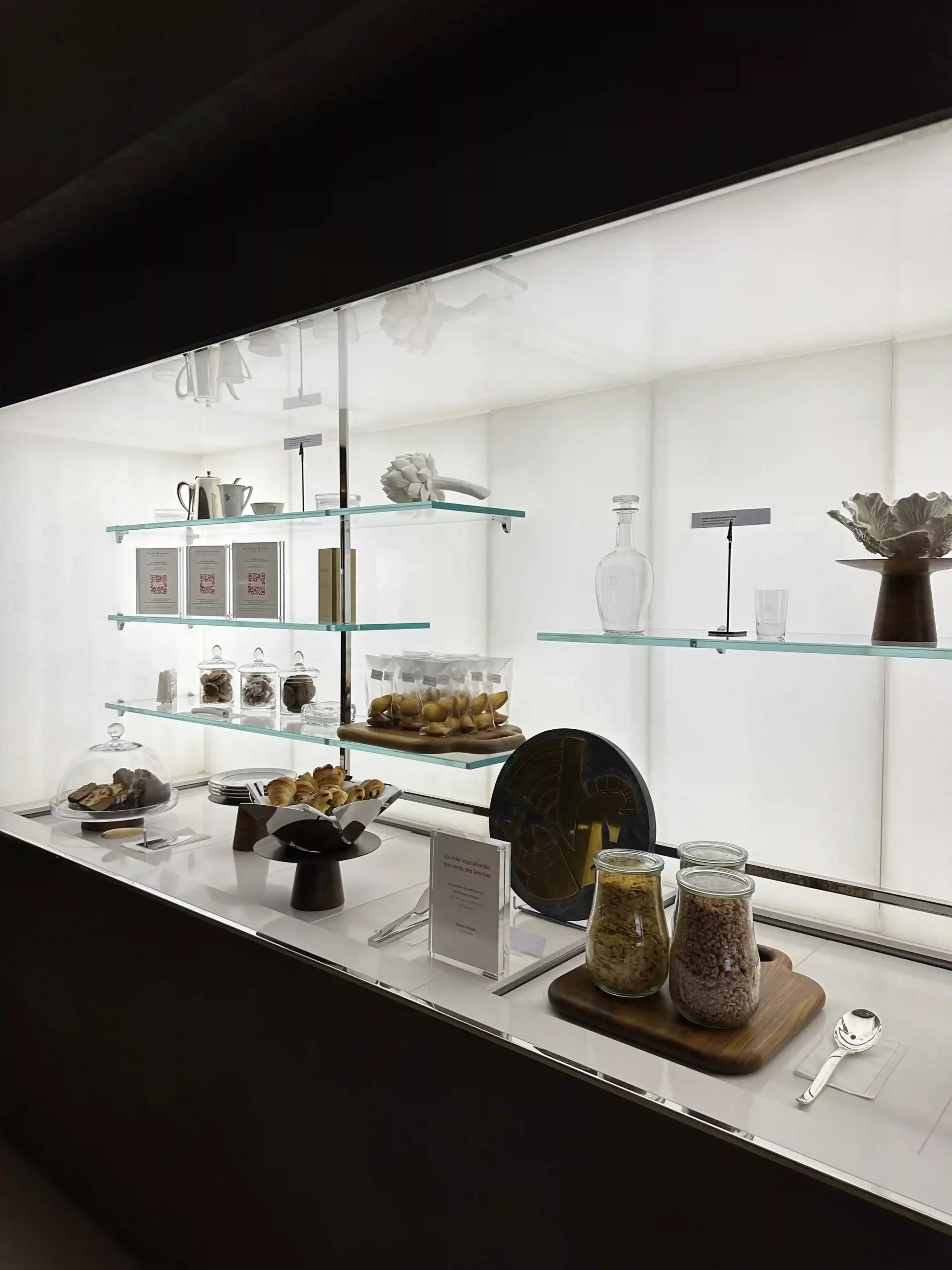 a display case with glass shelves and food items