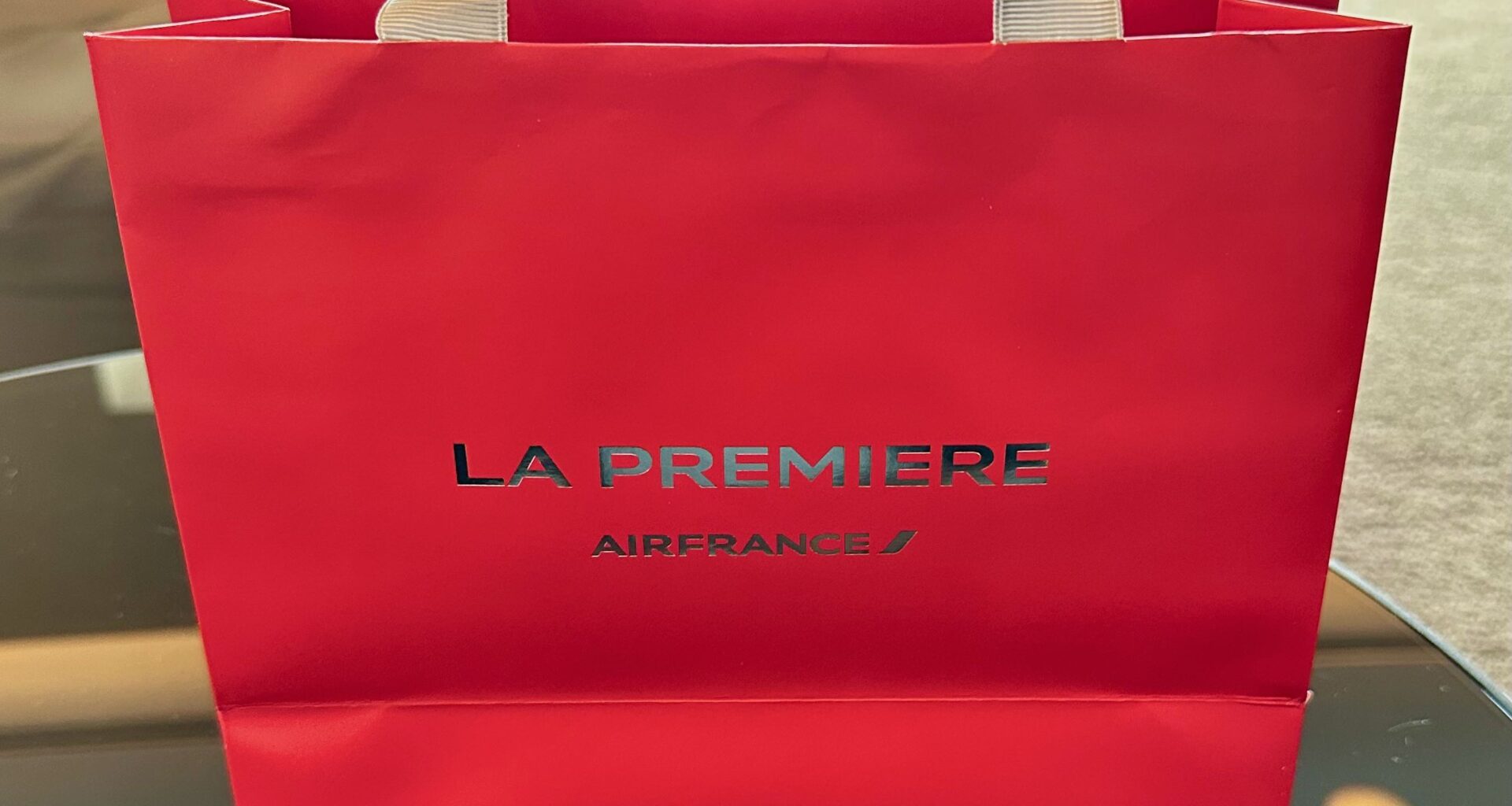 A red, La Premiere-branded paper bag