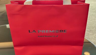 A red, La Premiere-branded paper bag
