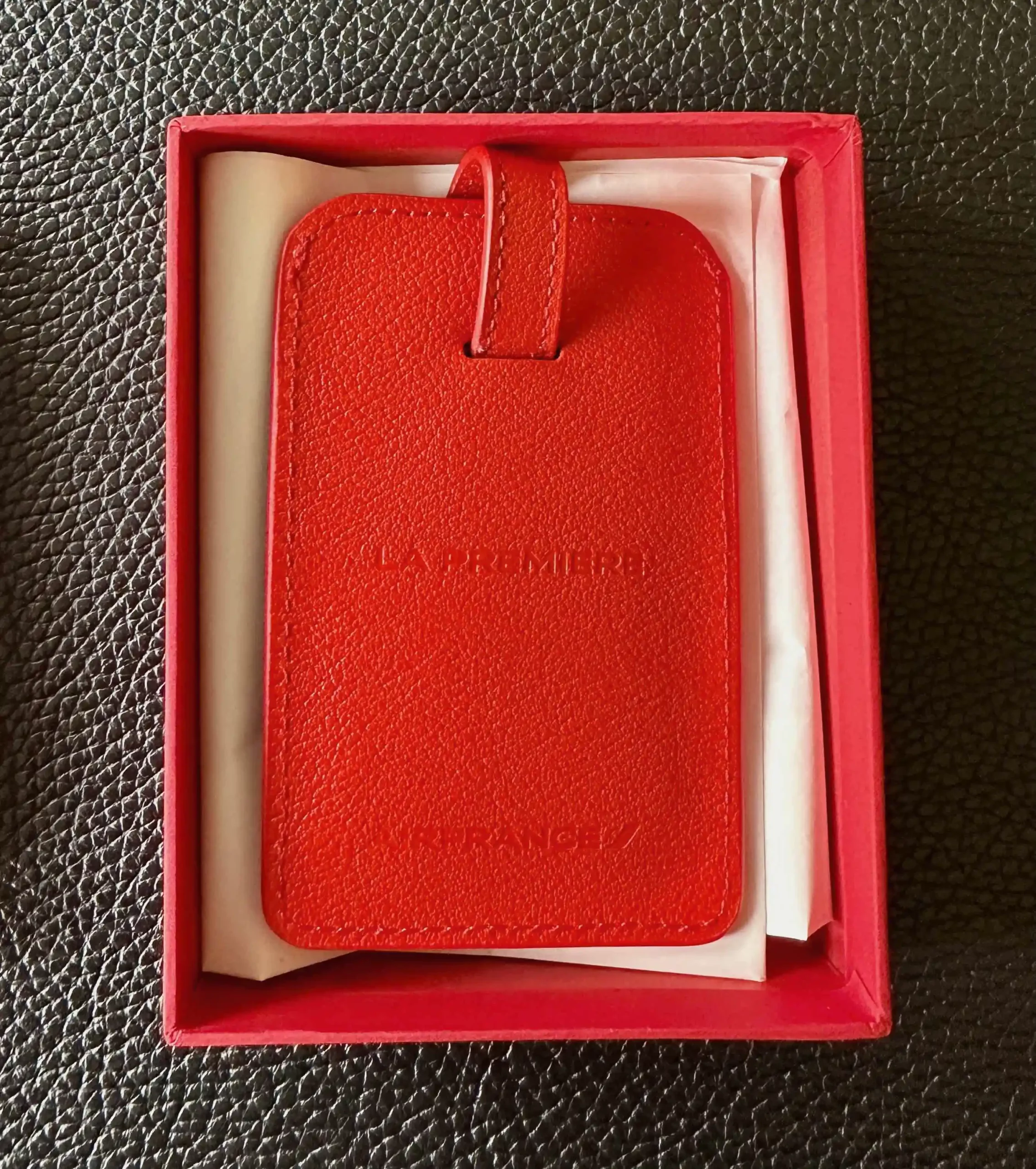 a red luggage tag in a box