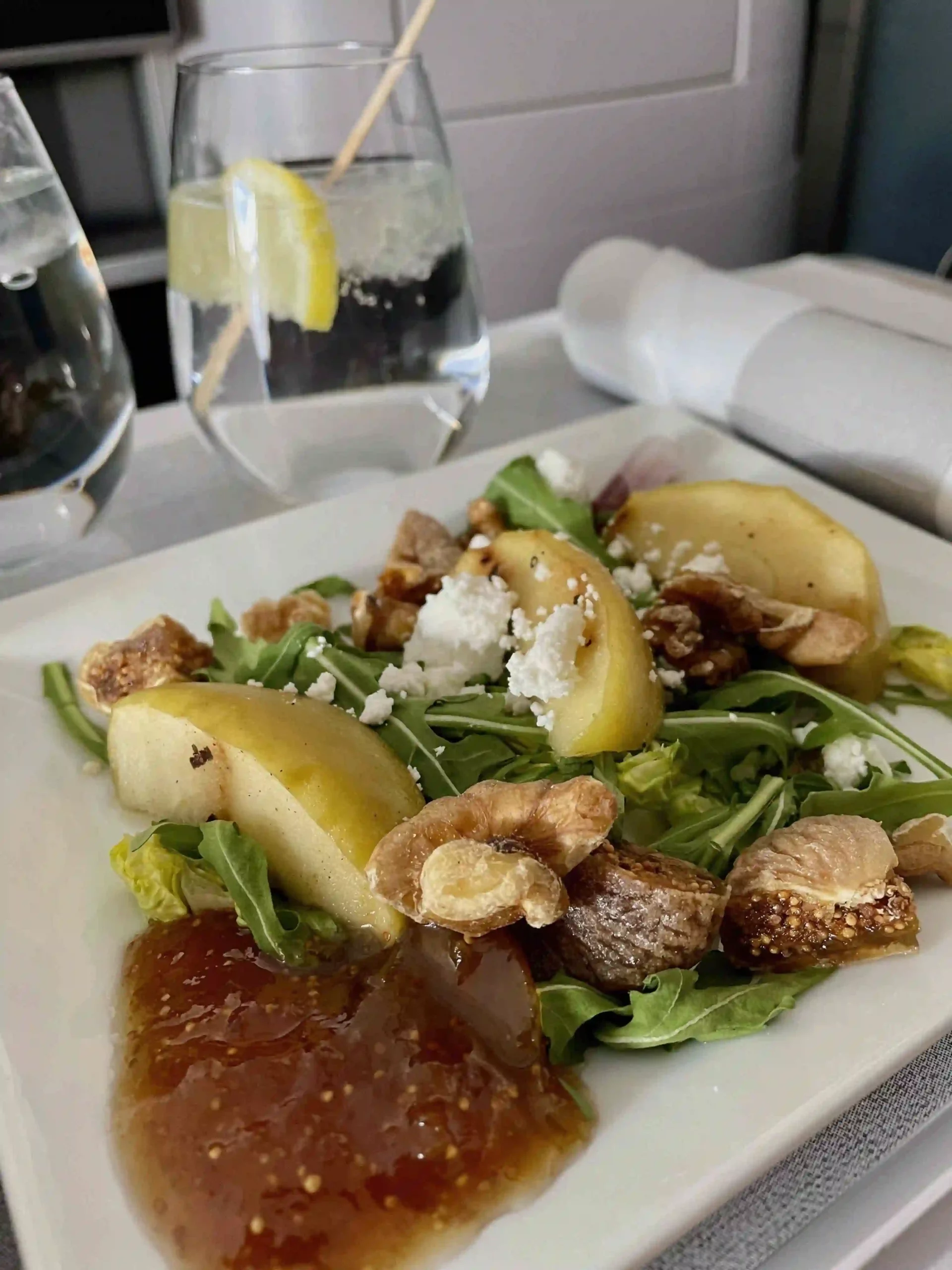 a plate of salad with fruit and nuts