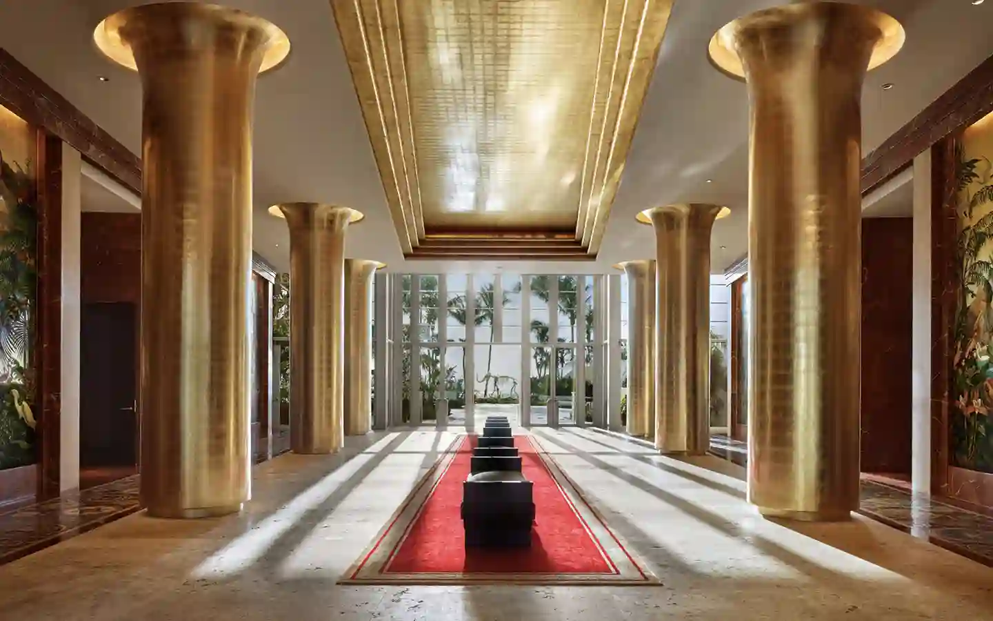 a hallway with columns and a red rug