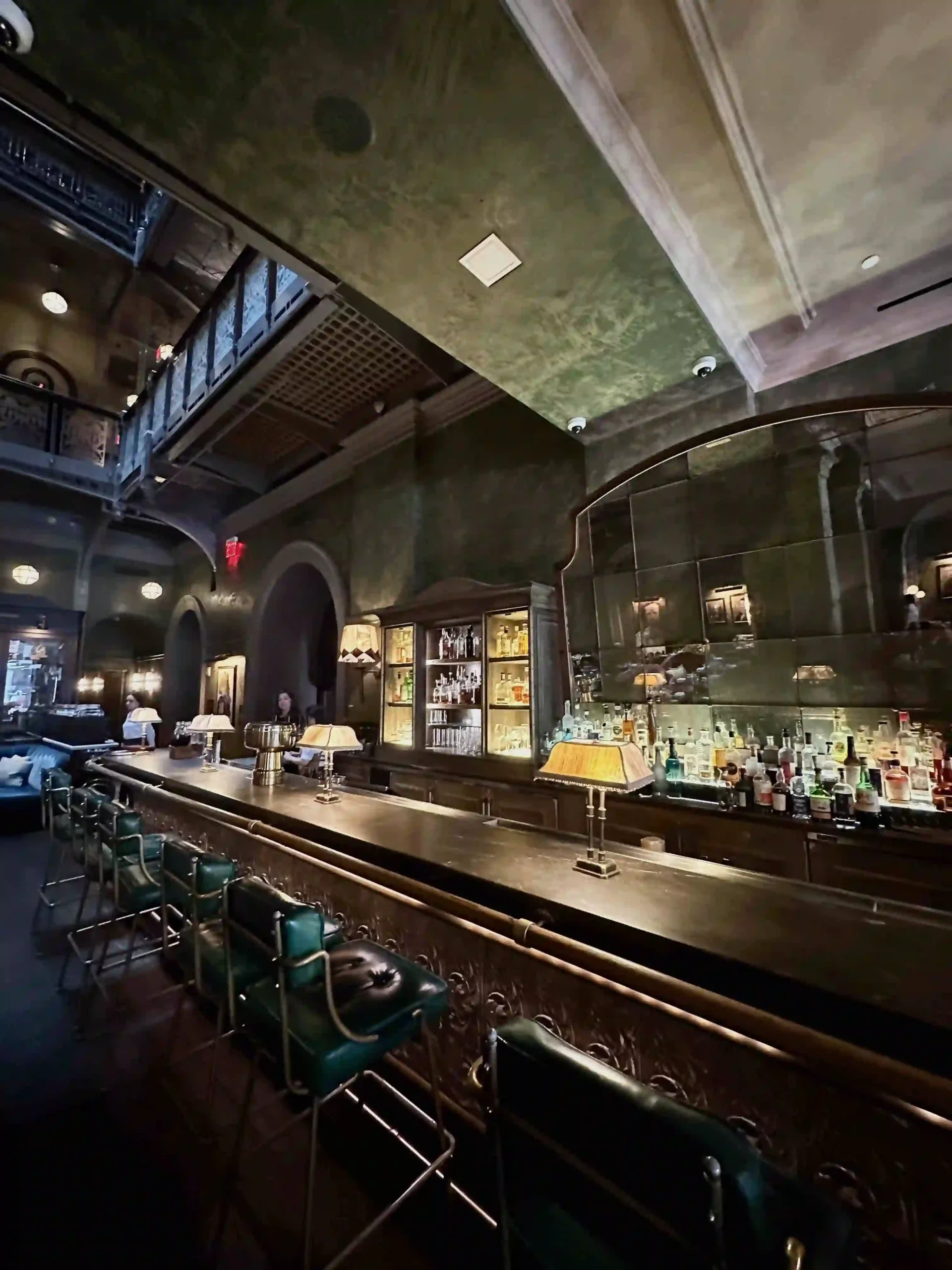 a bar with a mirror and chairs