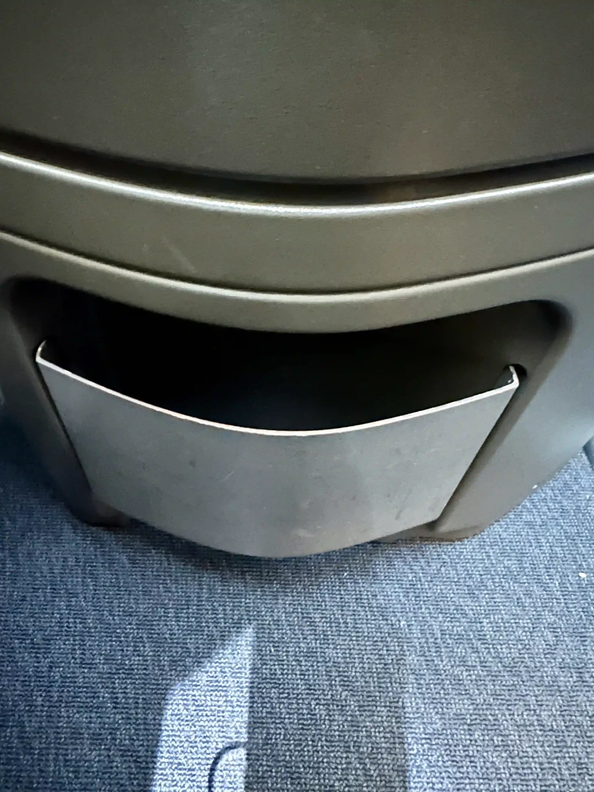 a metal bin on a carpet