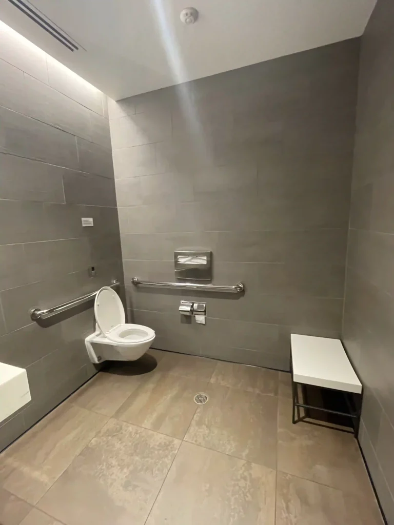 a bathroom with a toilet seat and a bench