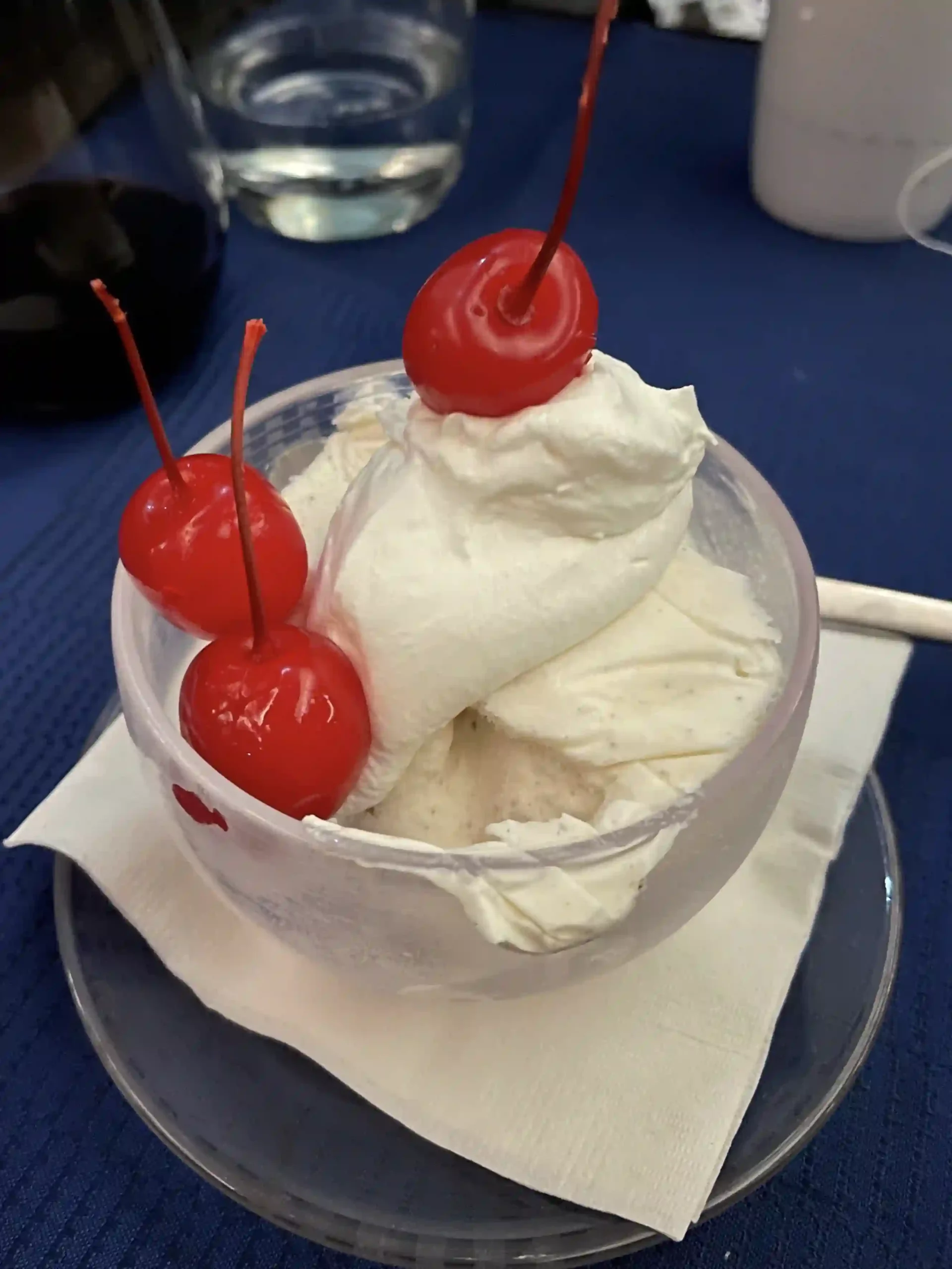 a cup of ice cream with cherries on top