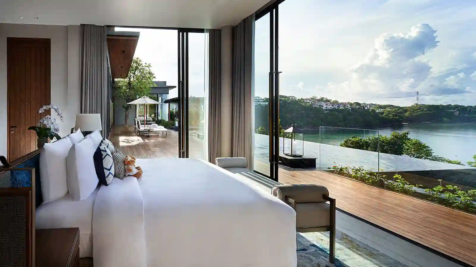 a room with a bed and a view of a body of water