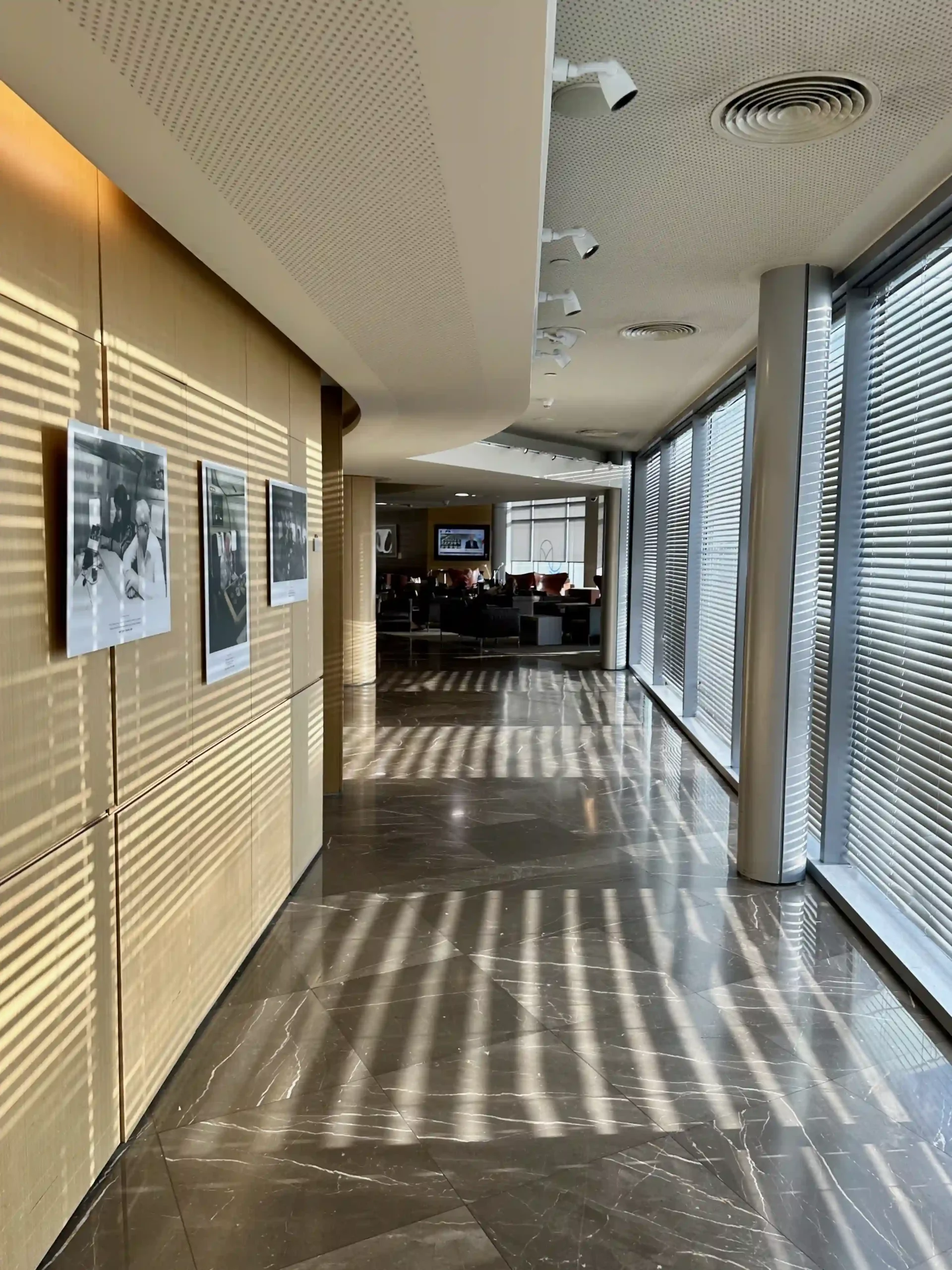 a hallway with blinds and pictures on the wall