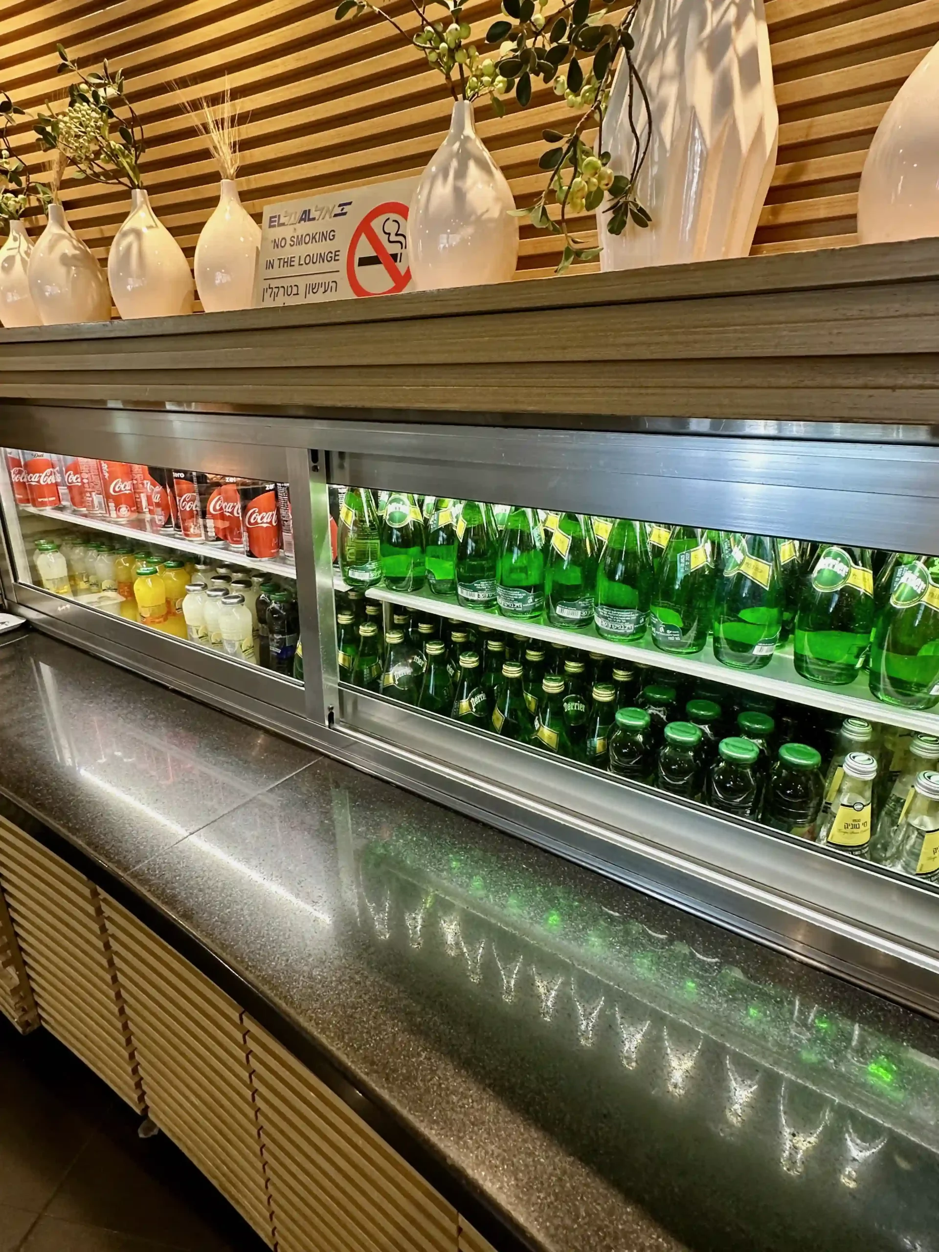 a display case with bottles of soda and bottles of liquid