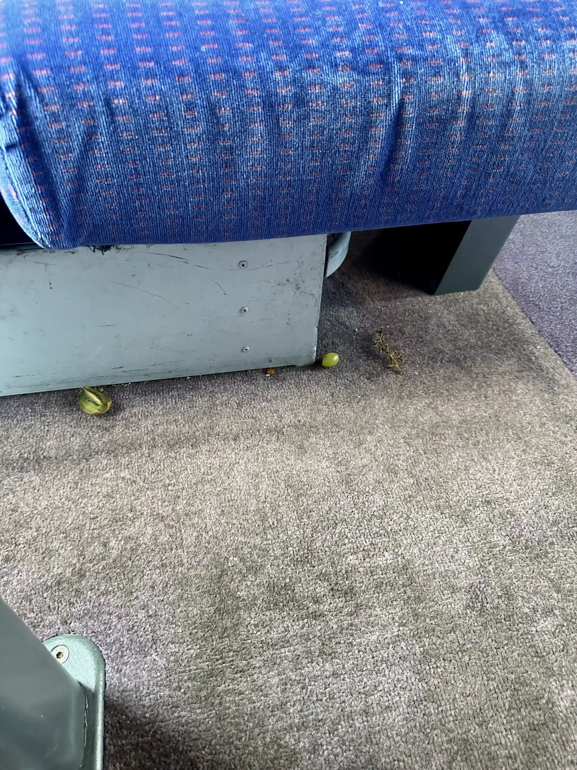 a carpeted floor with a blue cushion and a blue chair