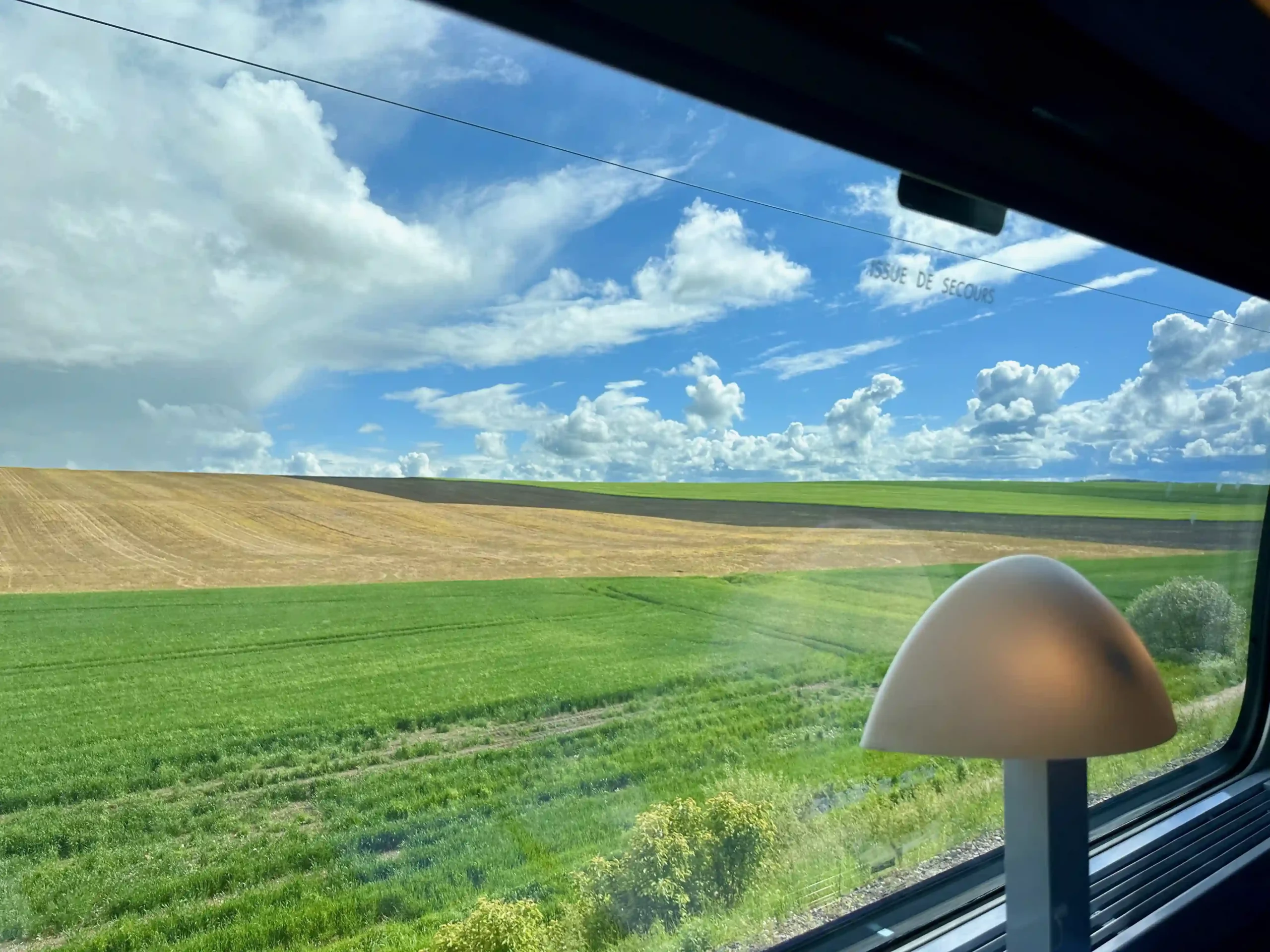 a view of a field from a train window