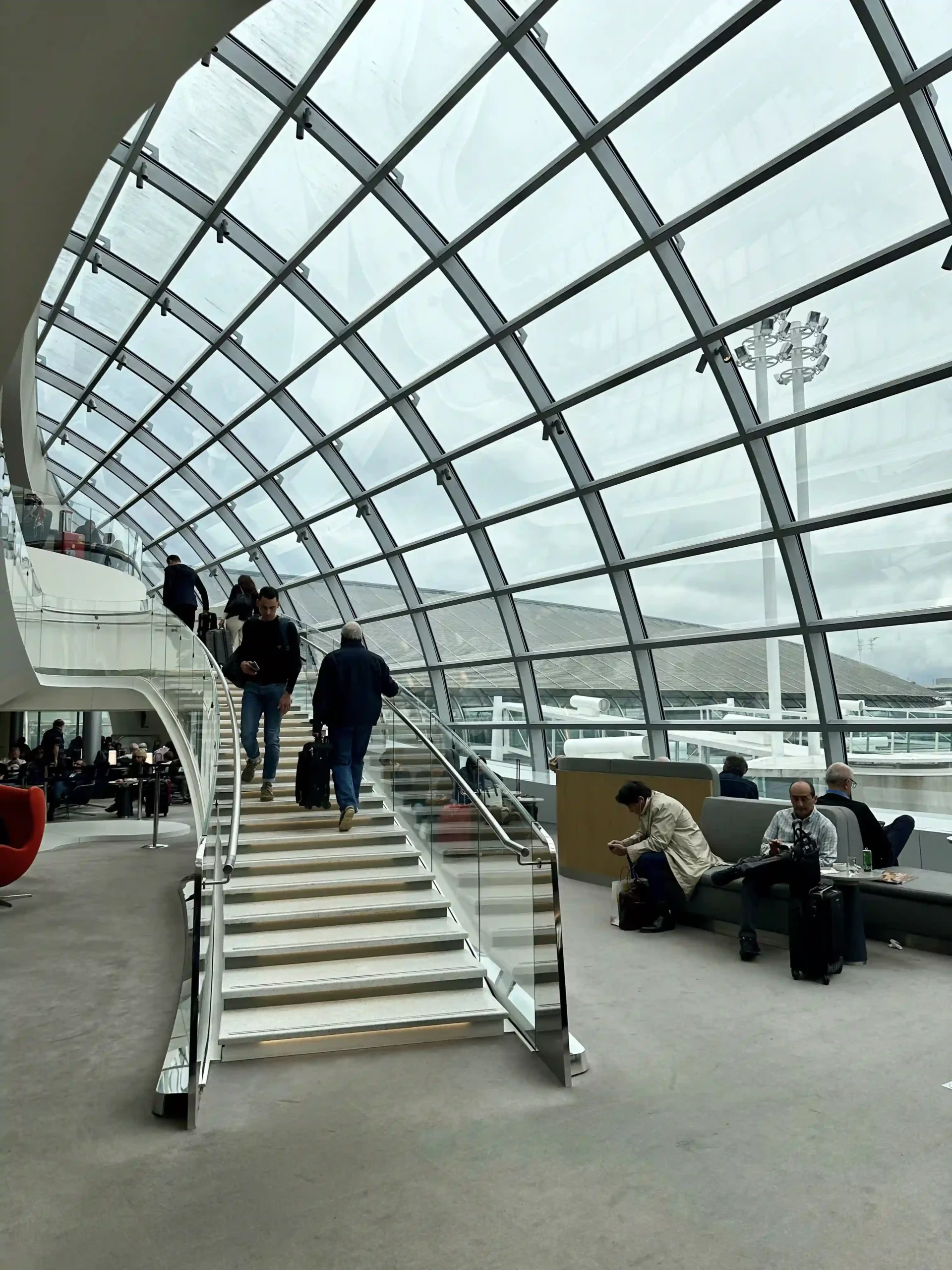 people walking up stairs in a glass room