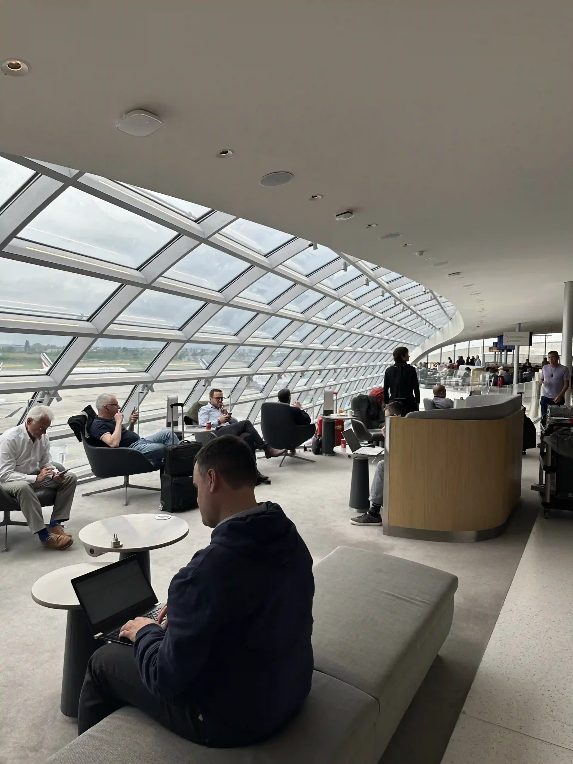 people sitting in chairs in a room with windows