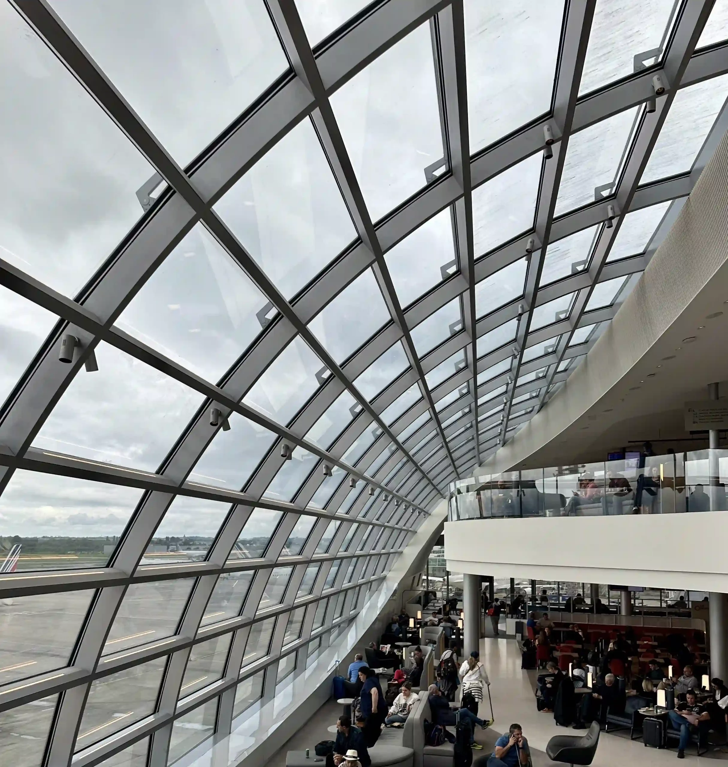 a large glass ceiling with people sitting in chairs