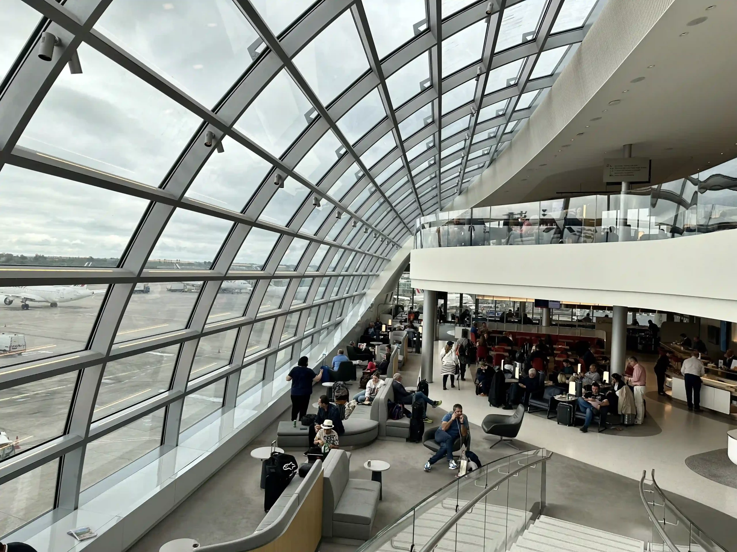 a large glass building with people sitting in it