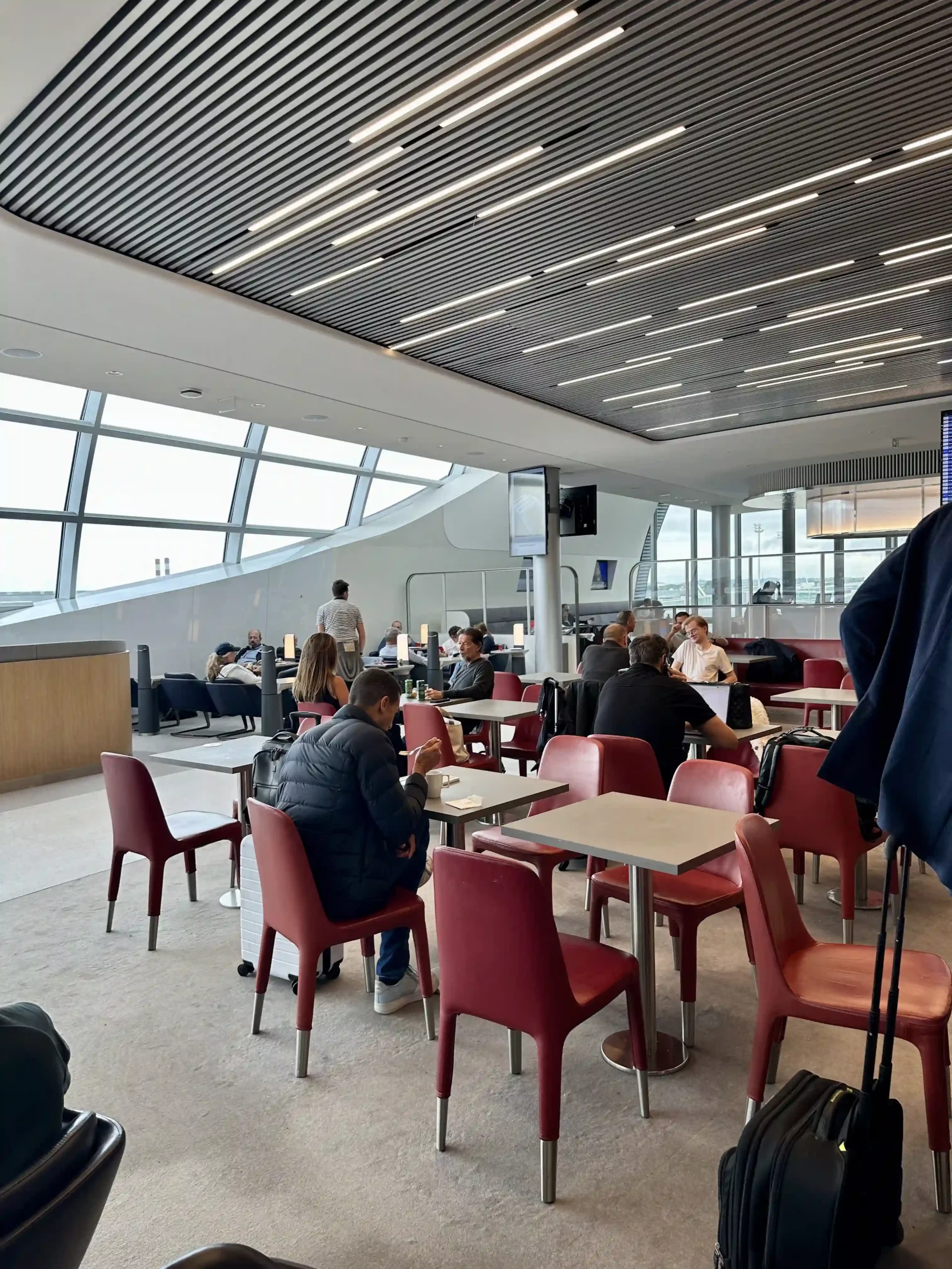 a group of people sitting at tables in a room with windows