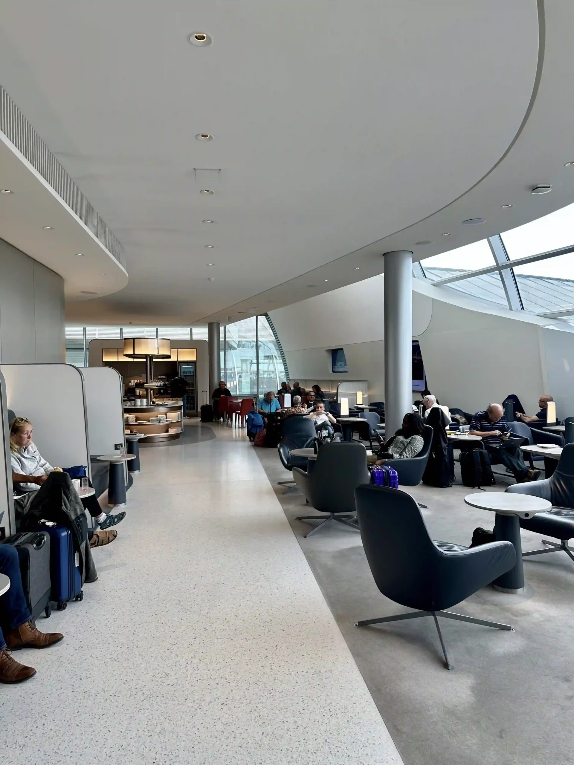 people sitting in a lounge area with chairs and tables