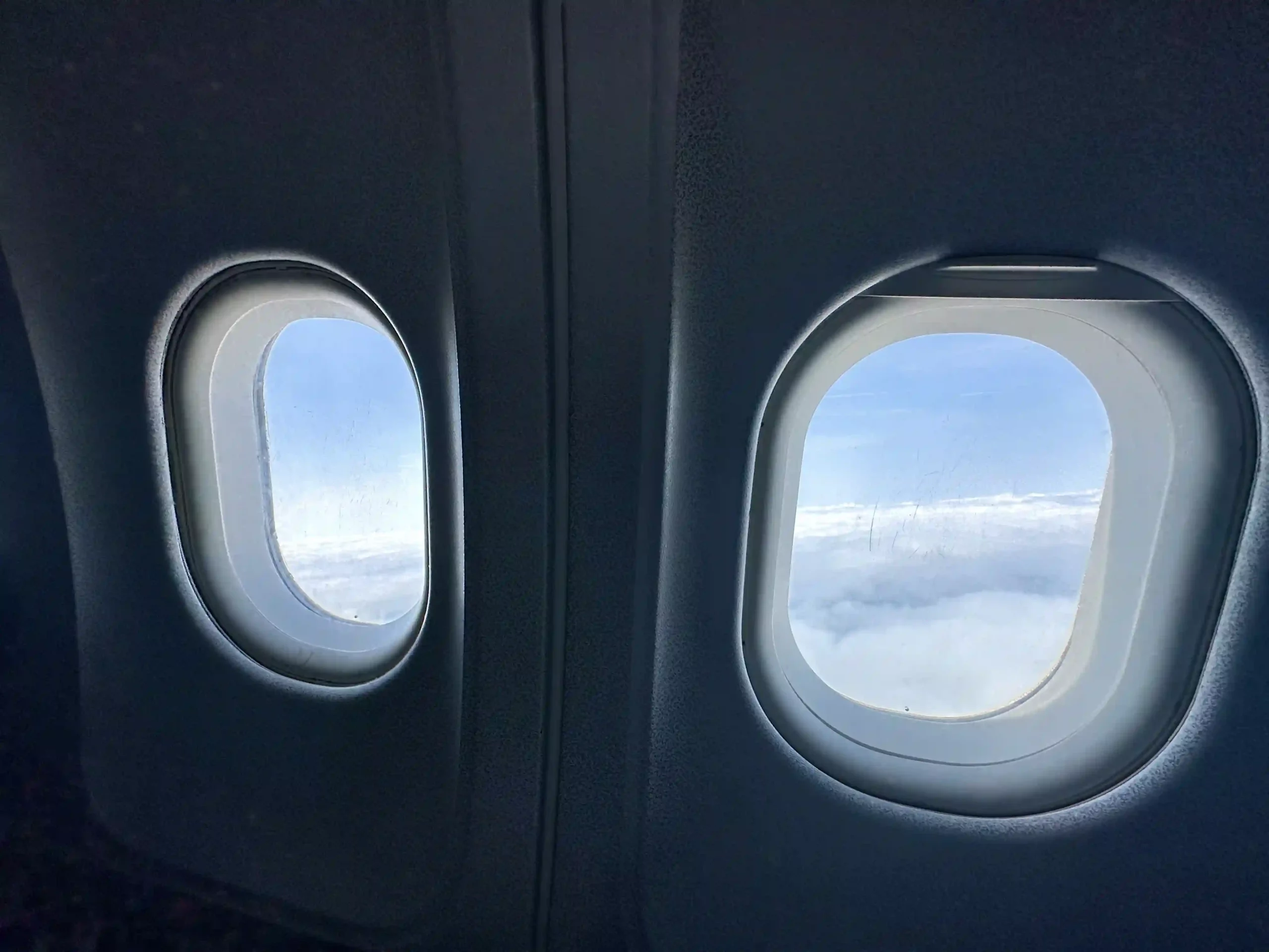 two windows with a view of clouds and blue sky