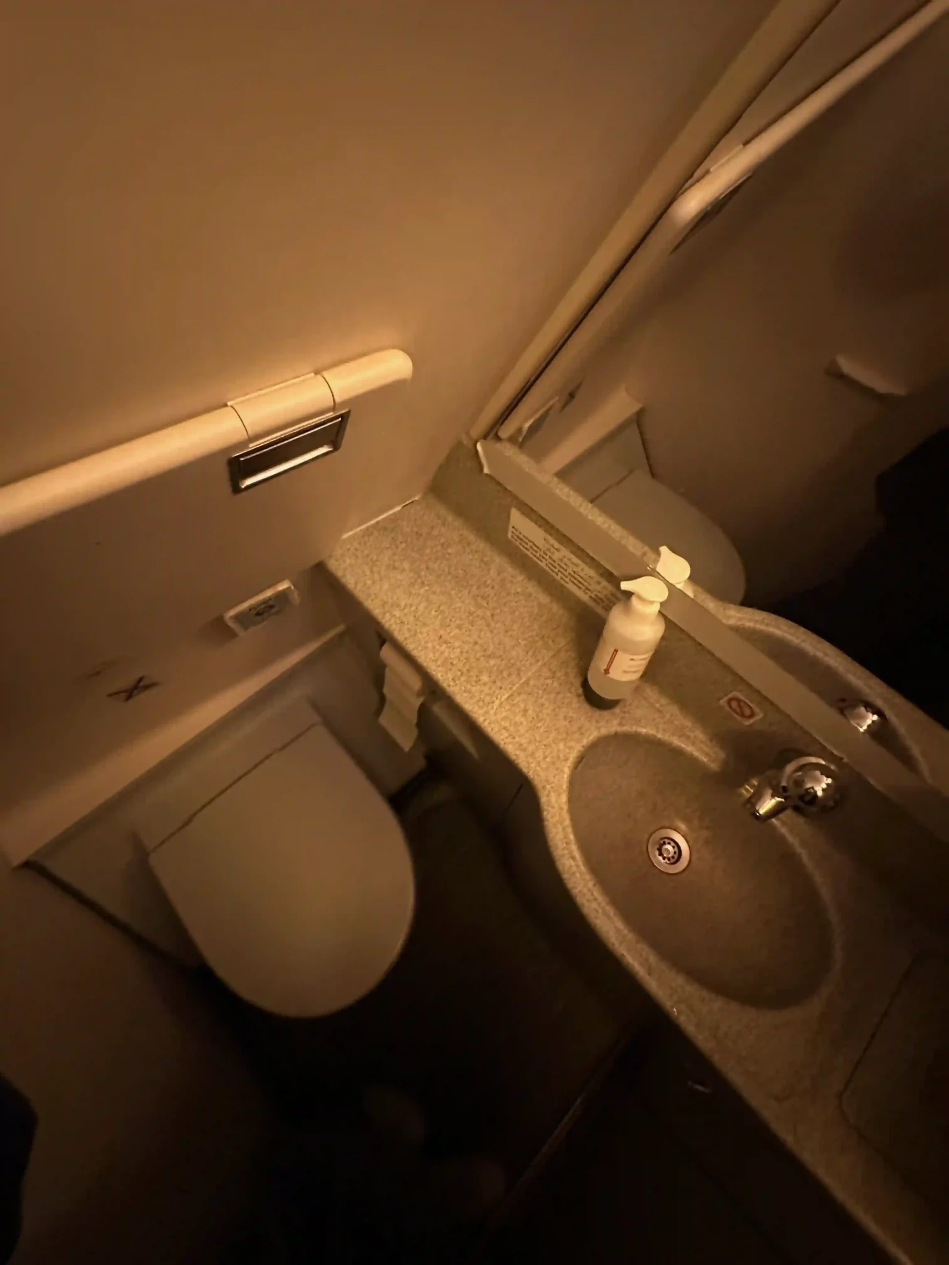 a bathroom with a sink and a soap dispenser