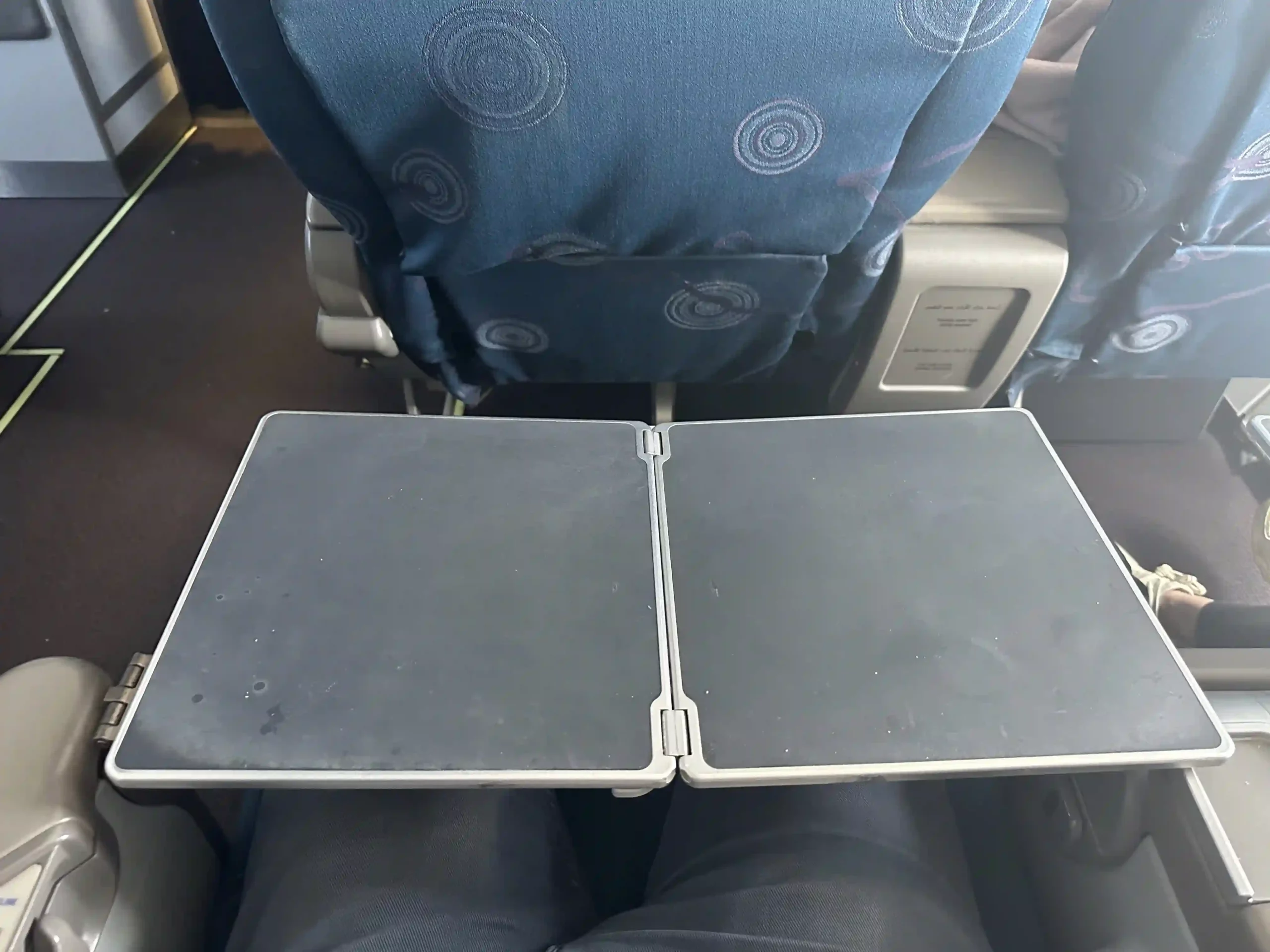 an airplane seat with a book on it
