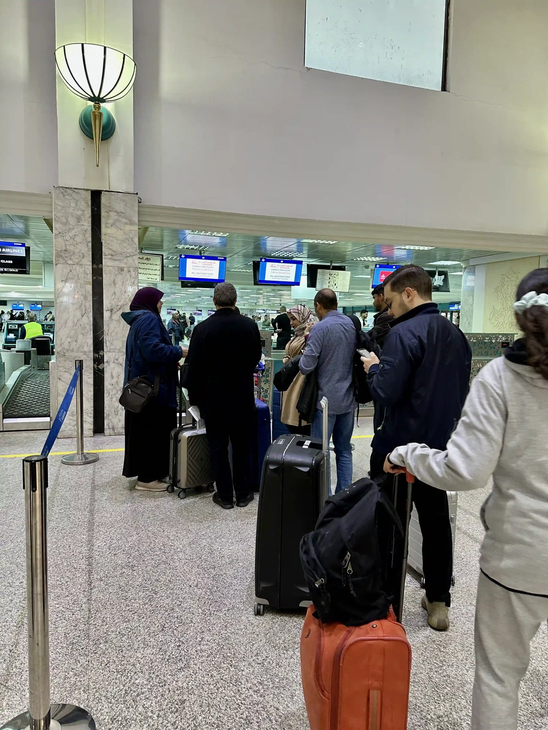 a group of people standing in a line with luggage