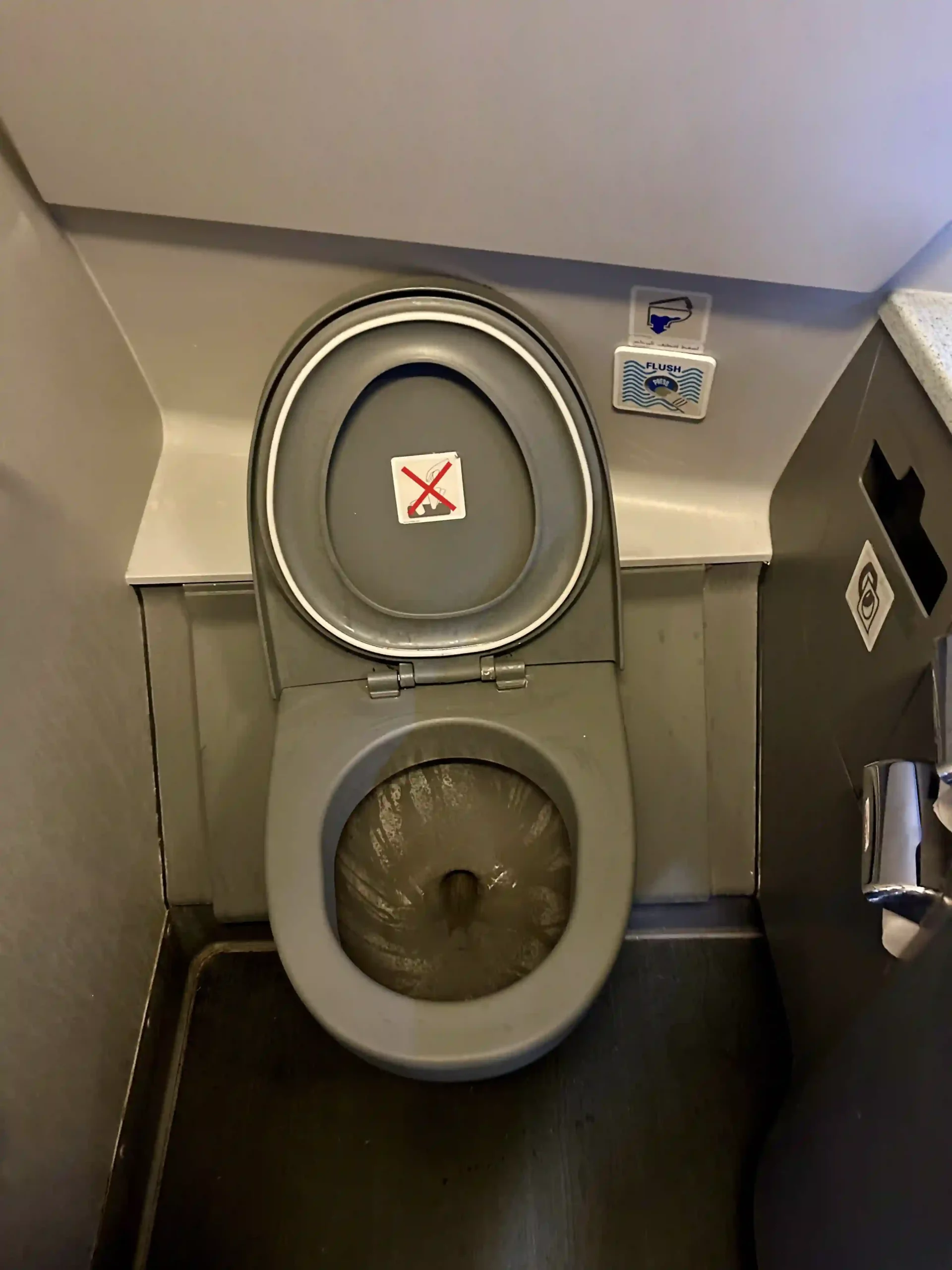 a toilet with a sign on the lid