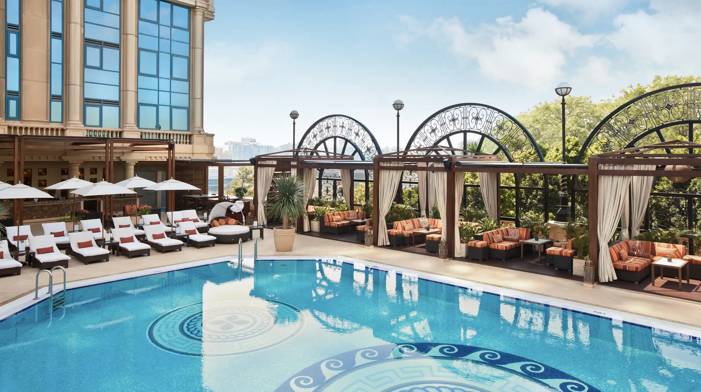 a pool with chairs and a building in the background