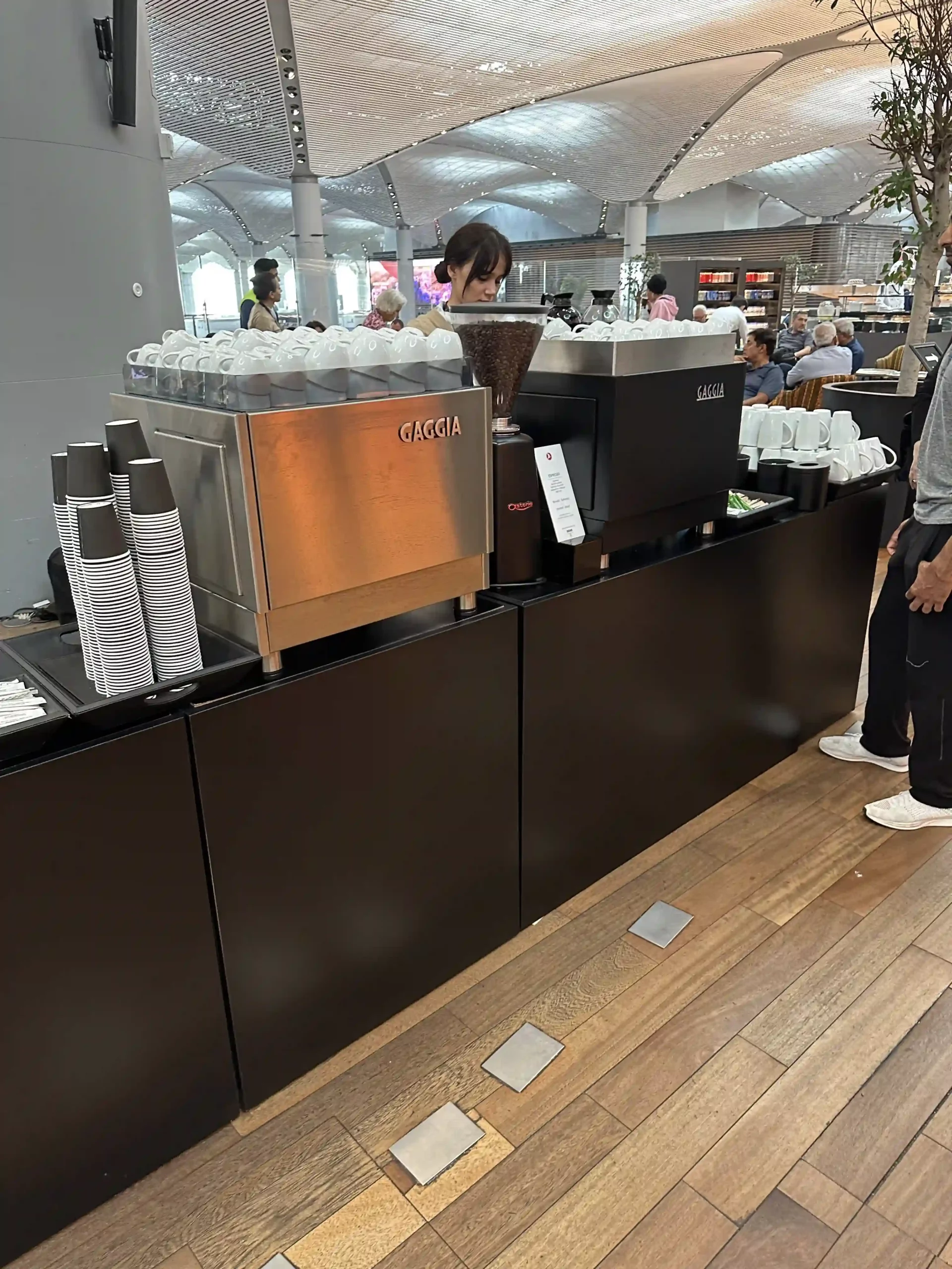 a woman standing at a coffee machine