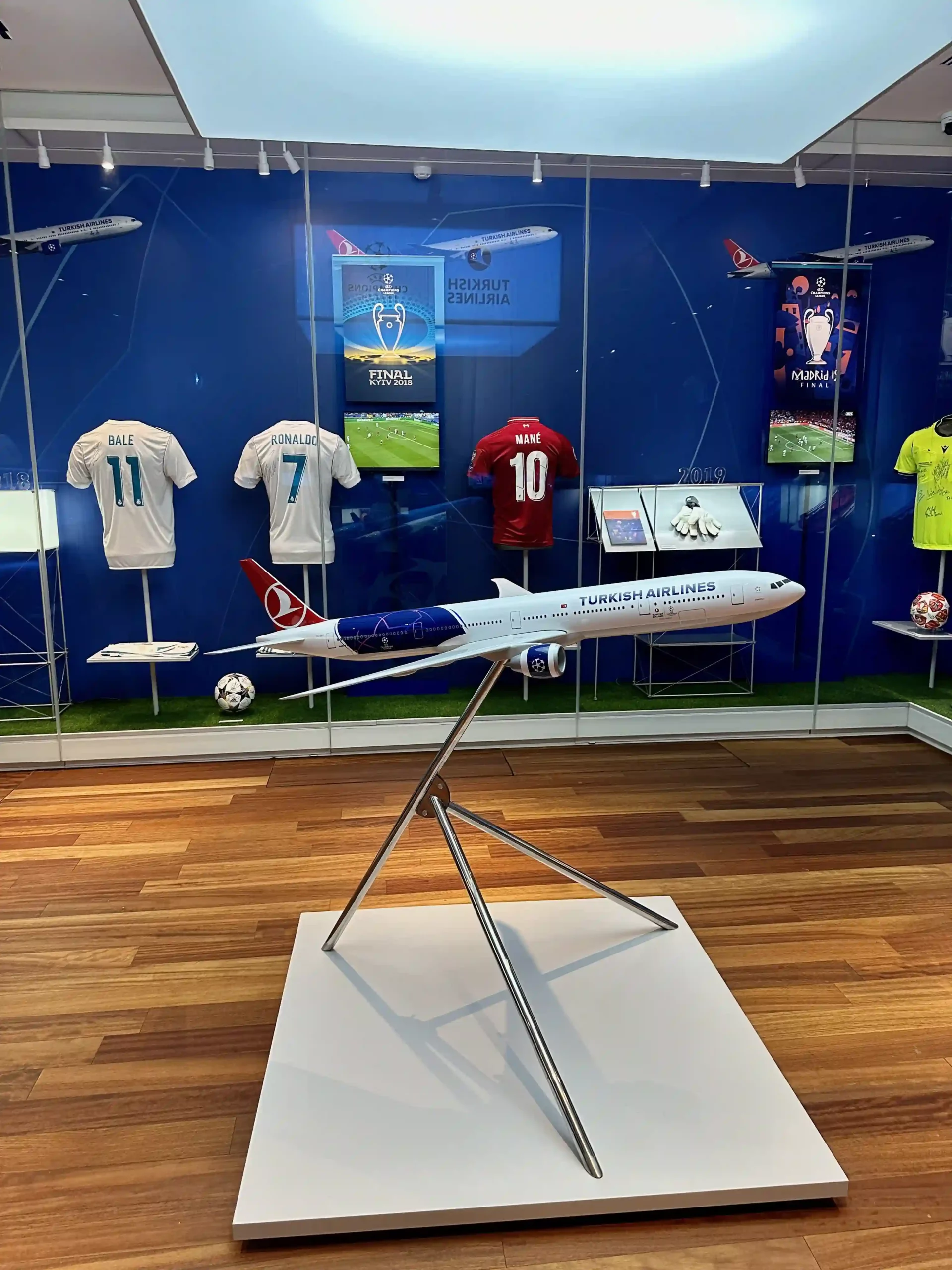 a model airplane on display in a room with football jerseys