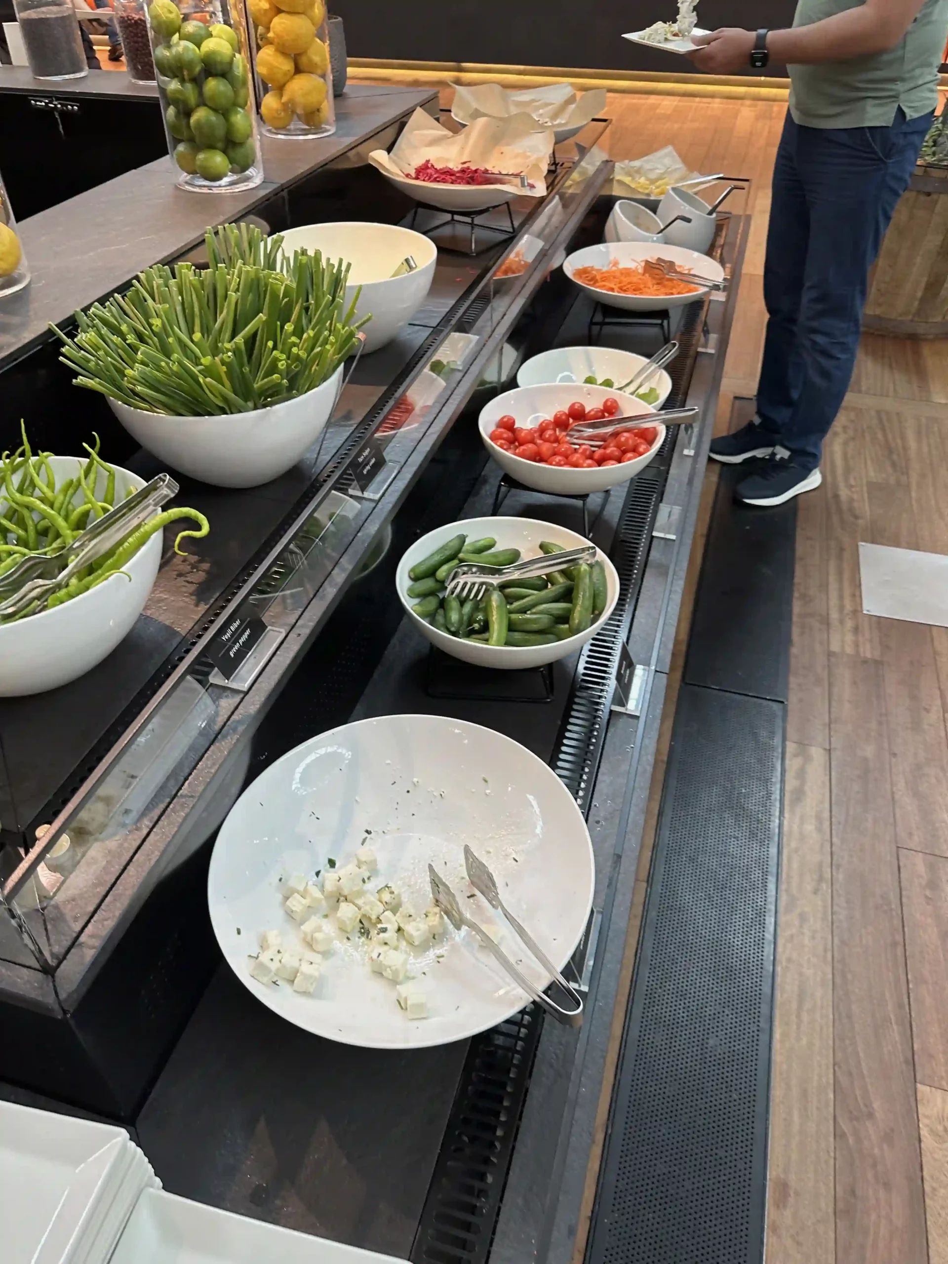 a buffet line with bowls of vegetables and fruits