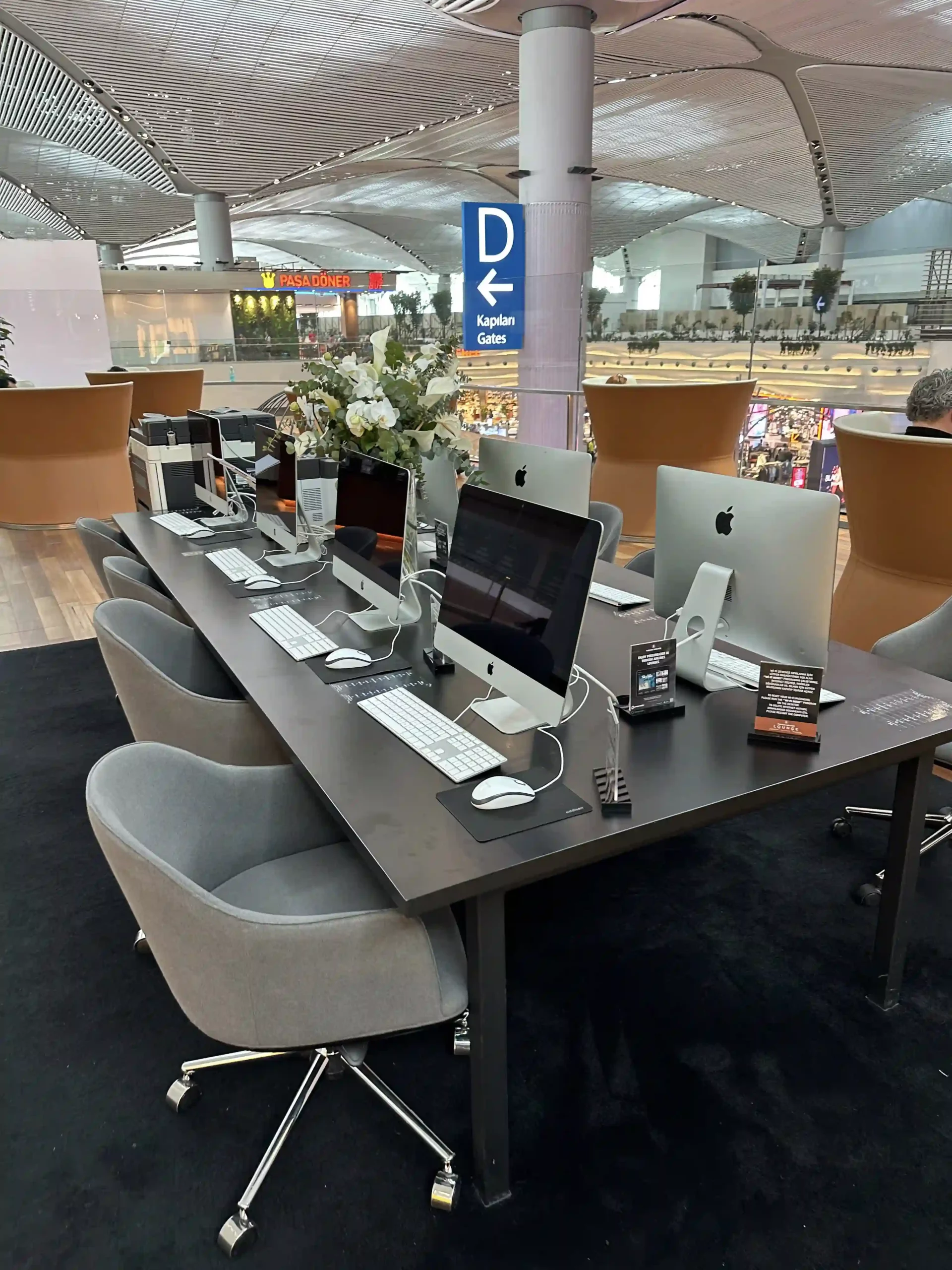 a desk with computers and chairs in a room