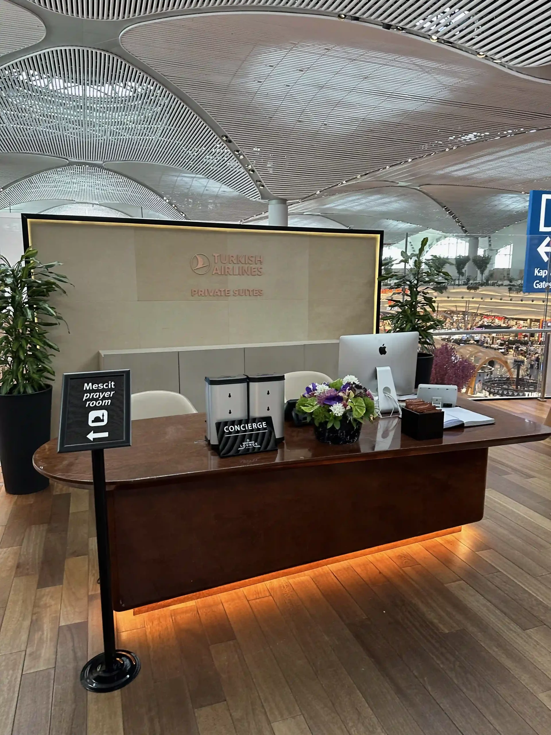 a desk with a sign and flowers on it