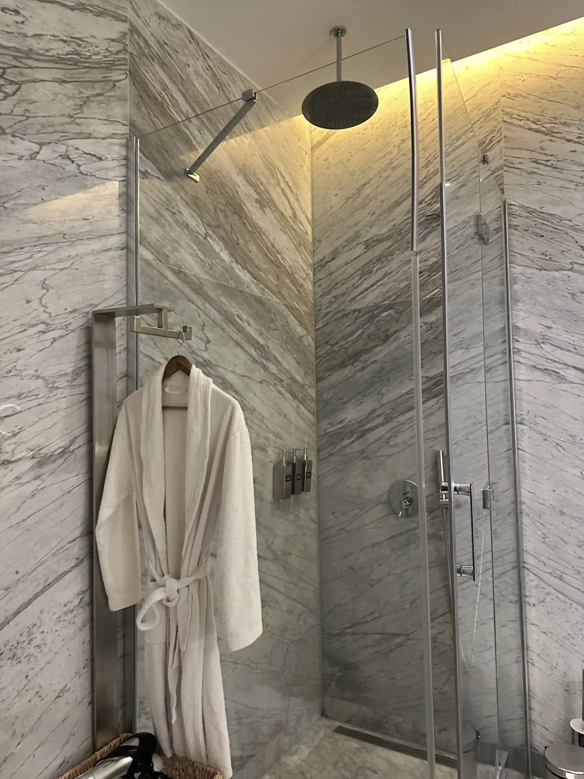 a white bathrobe on a metal bar in a bathroom