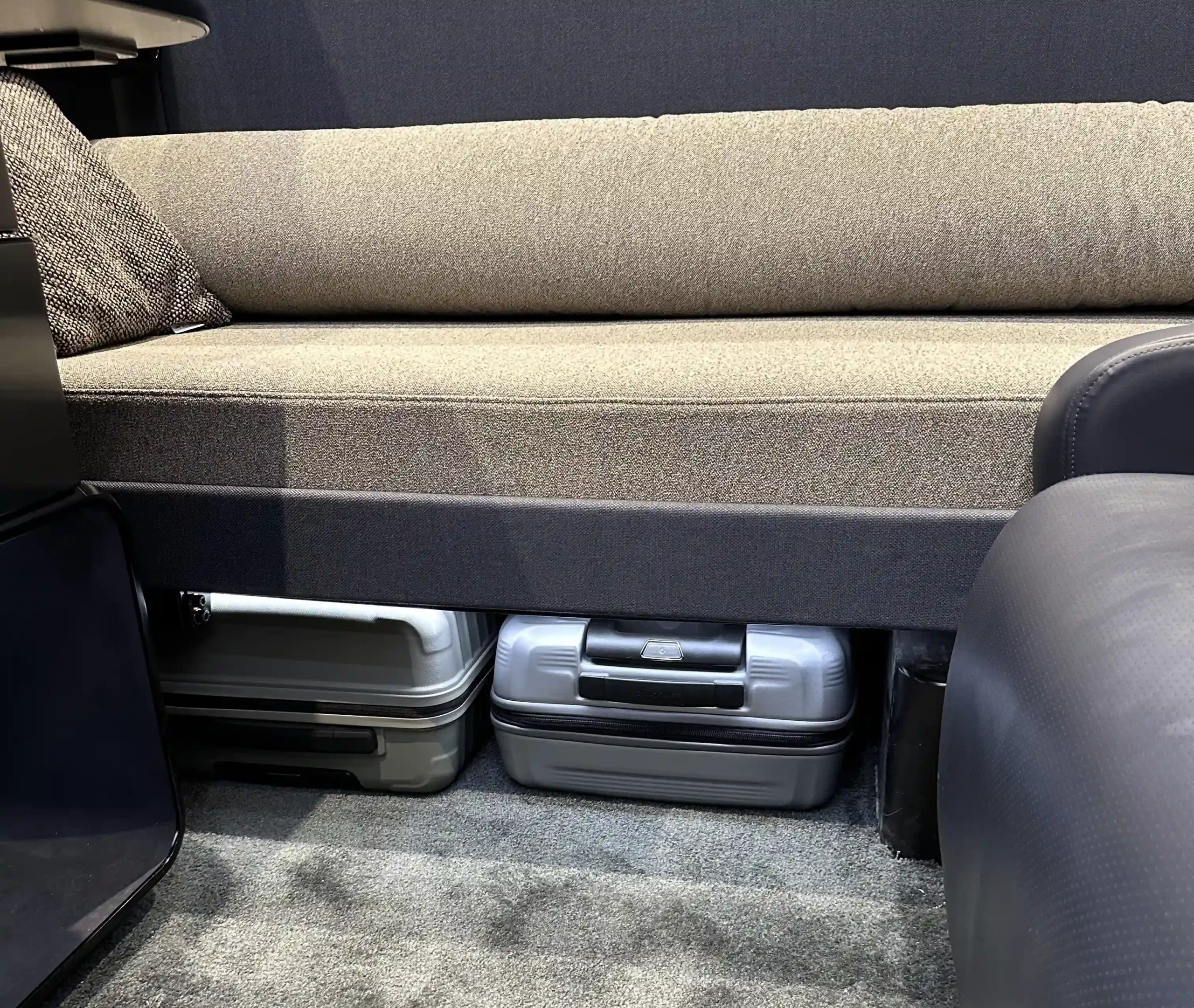 a couch with a carpeted seat and two luggage